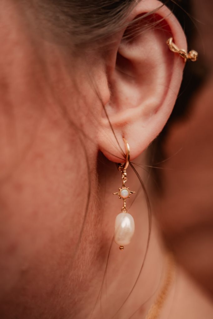 Close-up photos showing delicate pearl and gold dangle earrings from different angles on an ear.