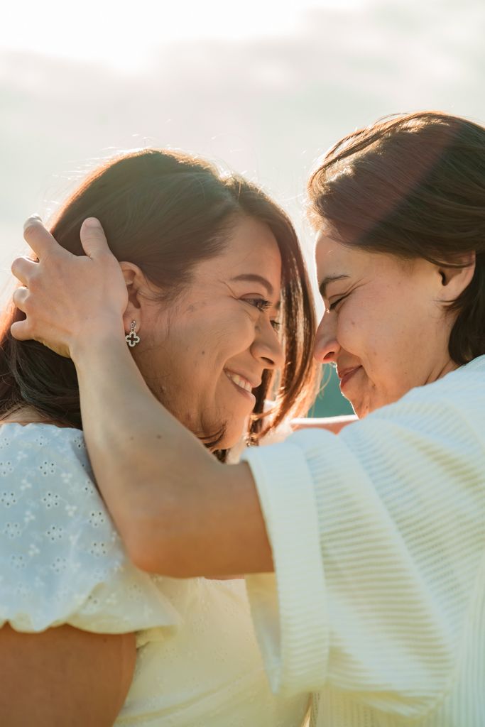 Two people sharing an intimate moment of laughter in golden sunlight.