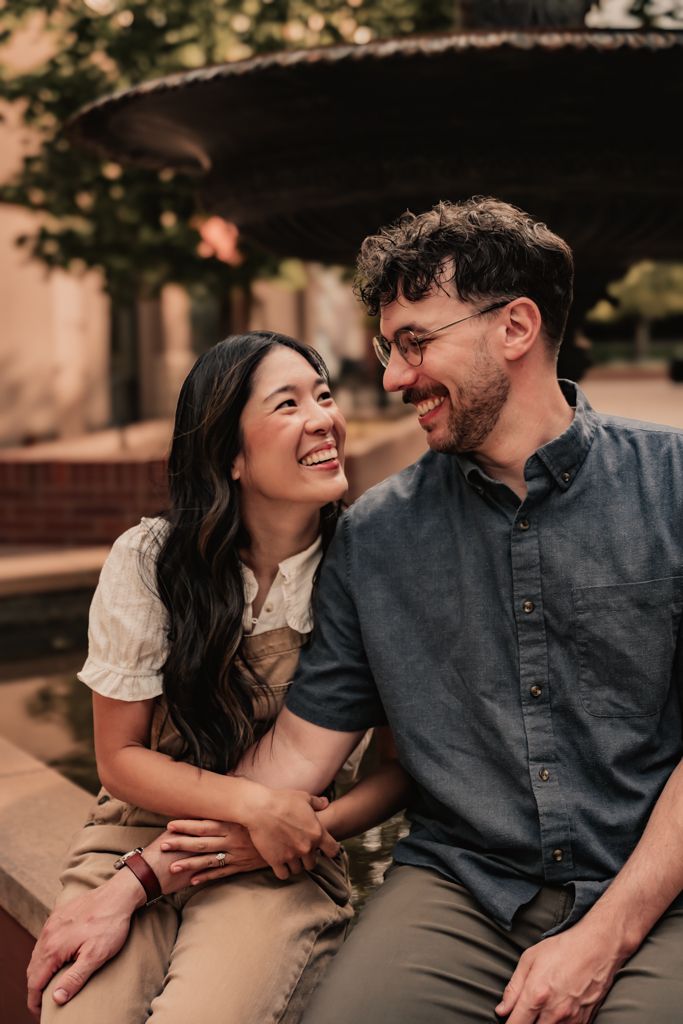 Couple sharing intimate laughing moment during casual outdoor photo session.