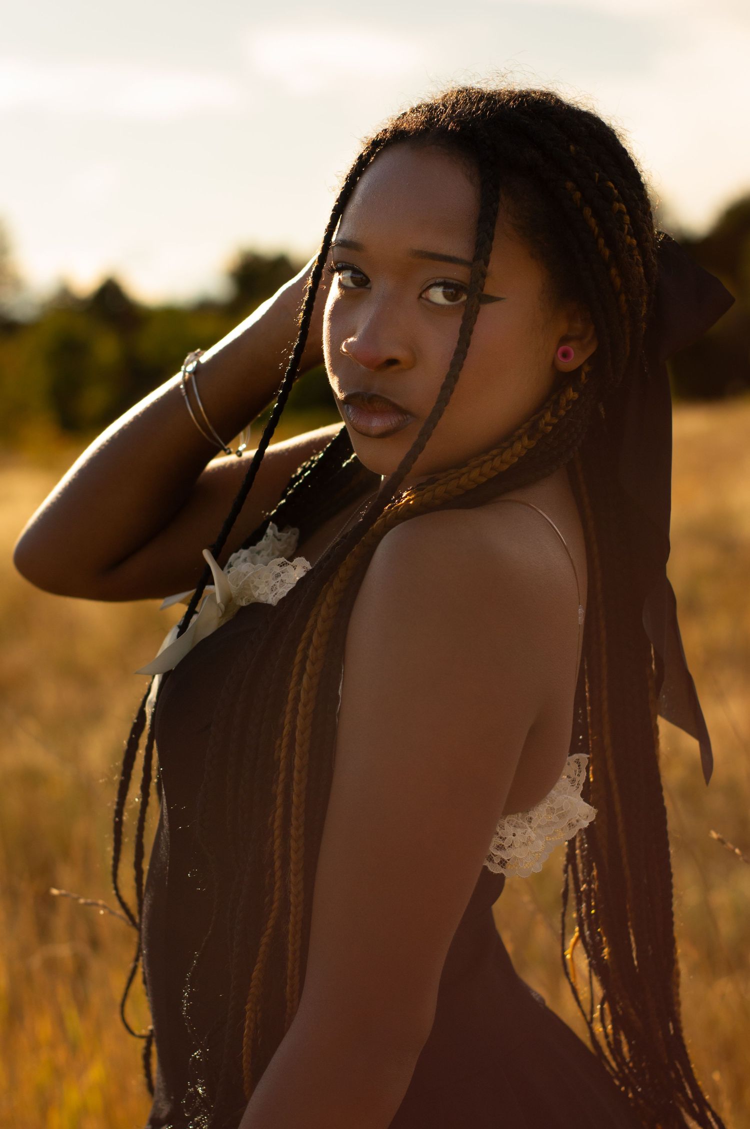 Profile portrait in warm sunlight against a field of tall grass.