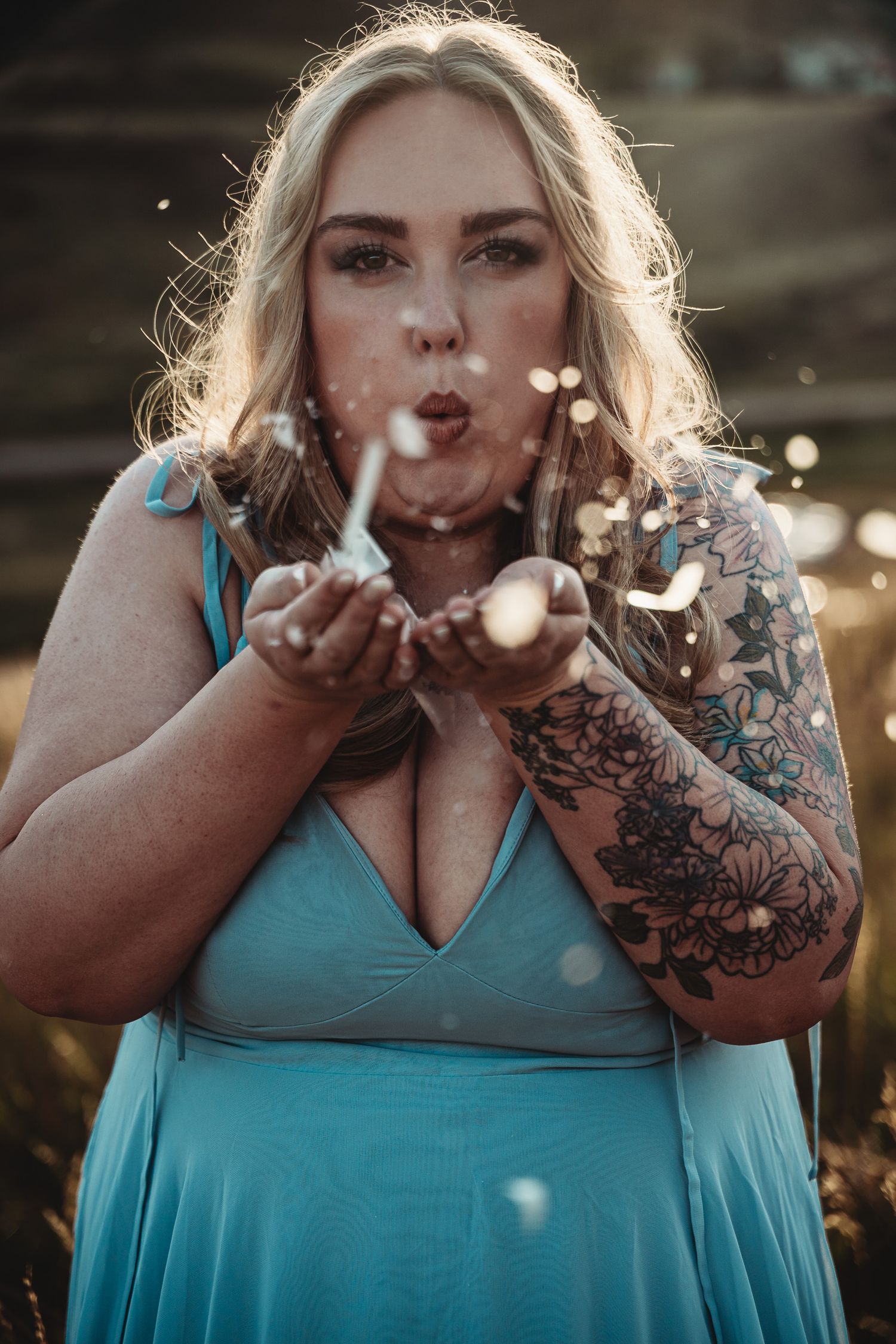 Person in turquoise dress blowing glitter in golden sunlight creating magical sparkles in a series of photos.