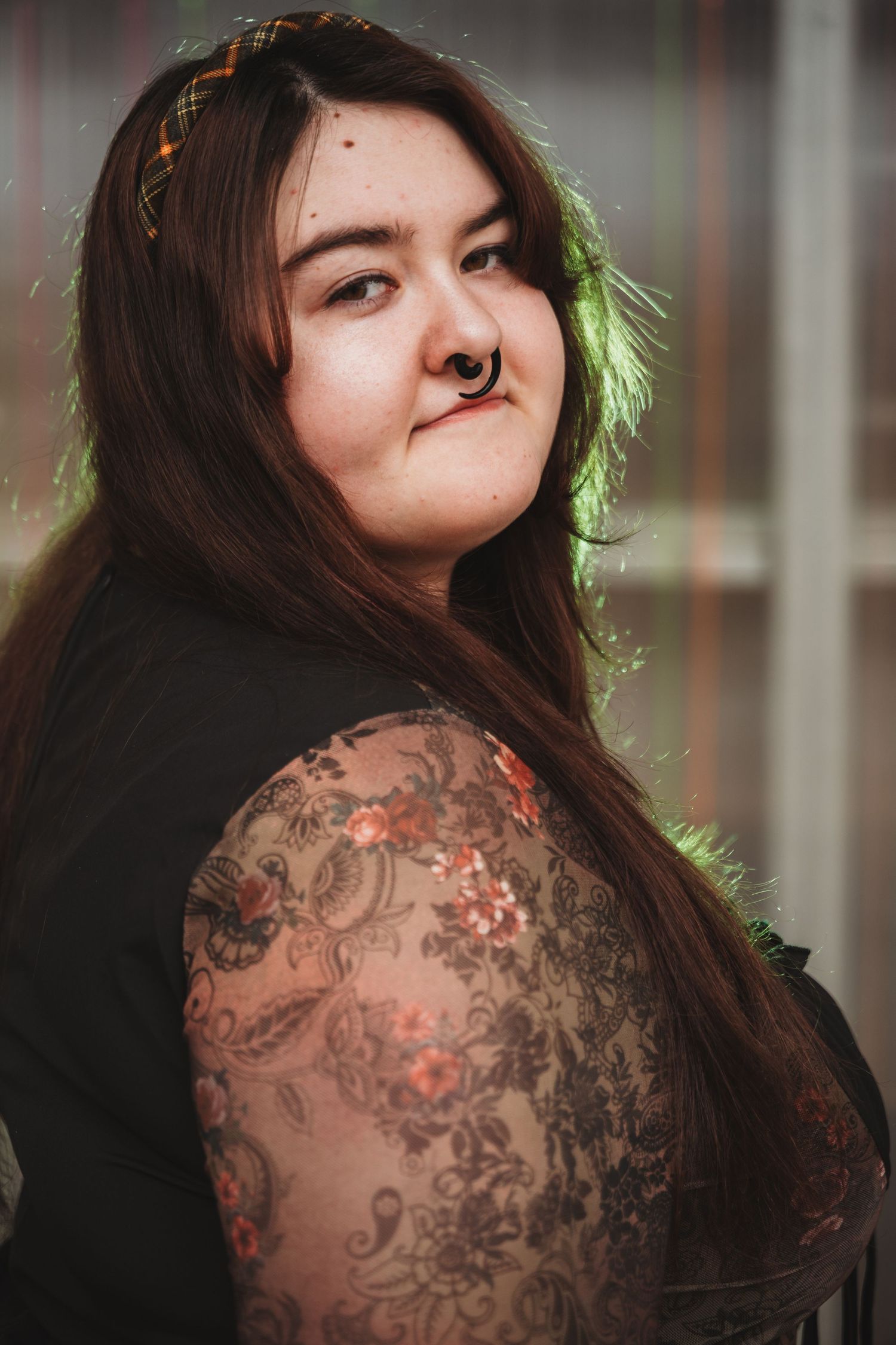A person with long dark hair and shoulder tattoos poses in a sequence of artistic portrait shots.