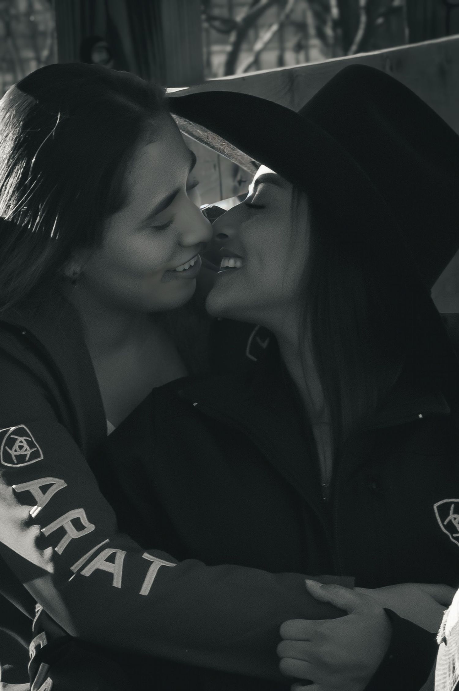 Black and white photo showing two people in athletic wear sharing an affectionate moment.