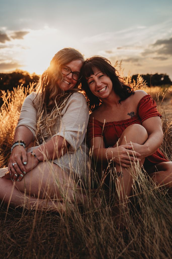 A couple embraces lovingly in a golden wheat field at sunset, creating a romantic silhouette against the warm sky.