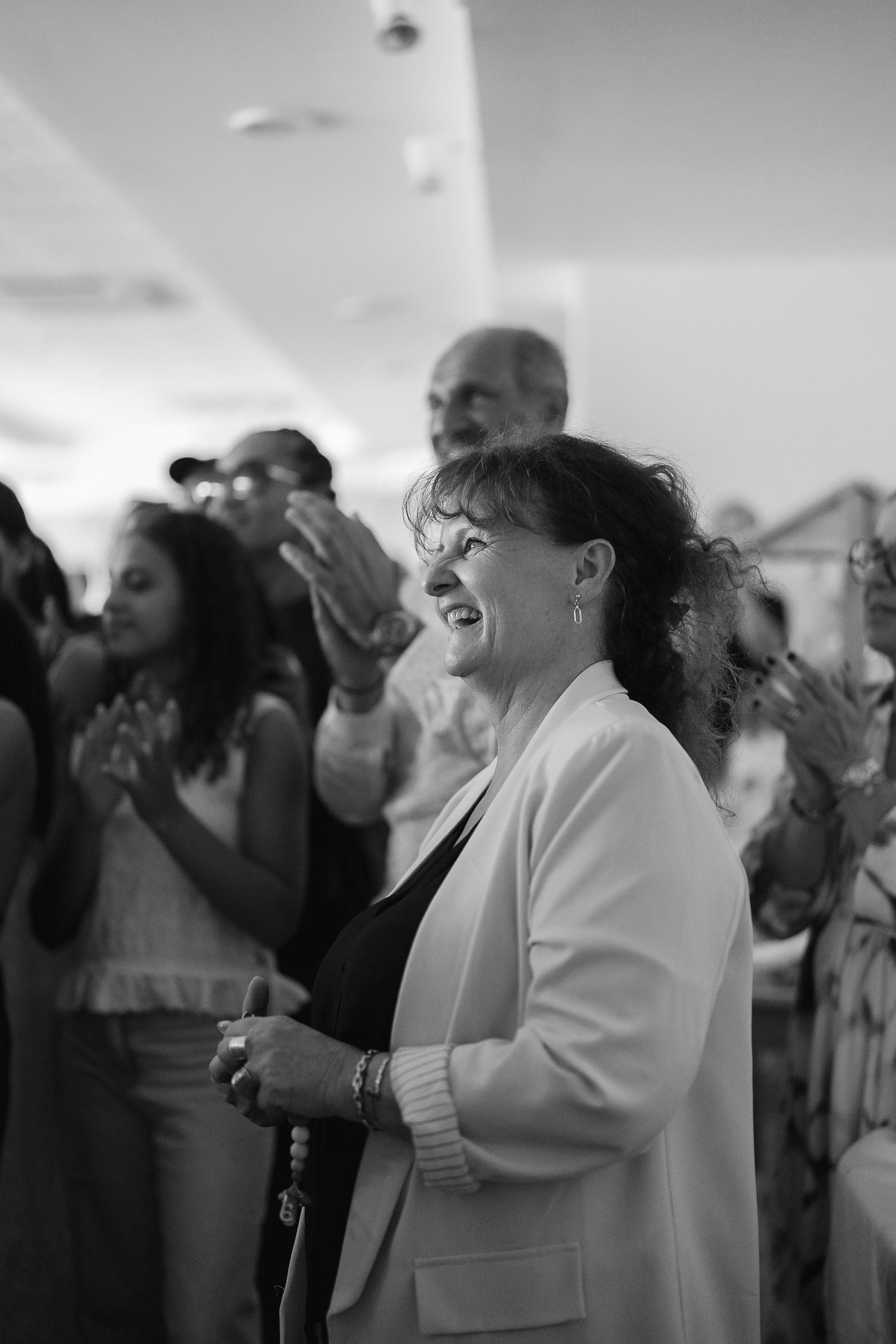 A joyful crowd of wedding guests dancing and celebrating at a reception.