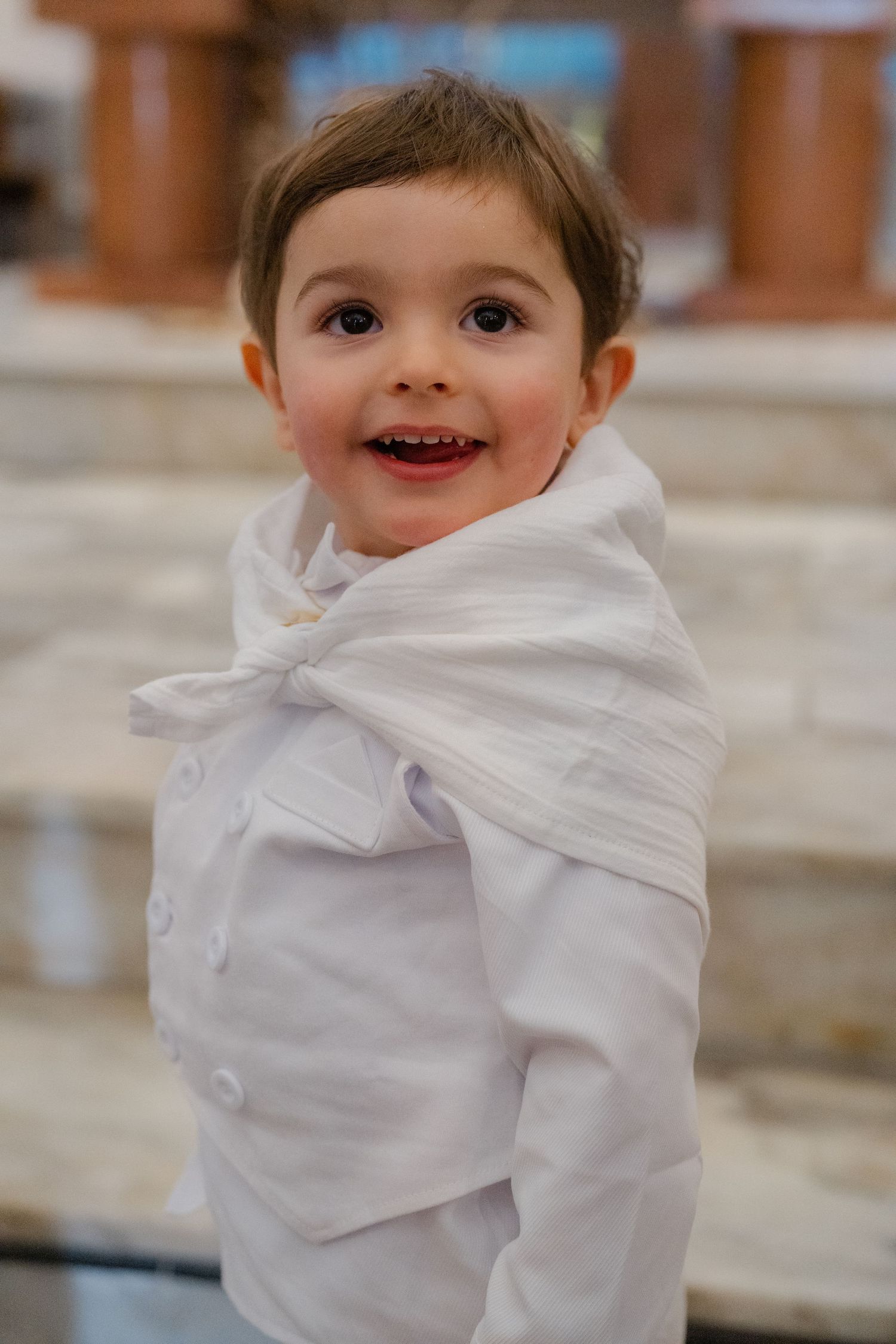 A series of photos showing a child's playful expressions while wearing a white cloth wrapped around their face.