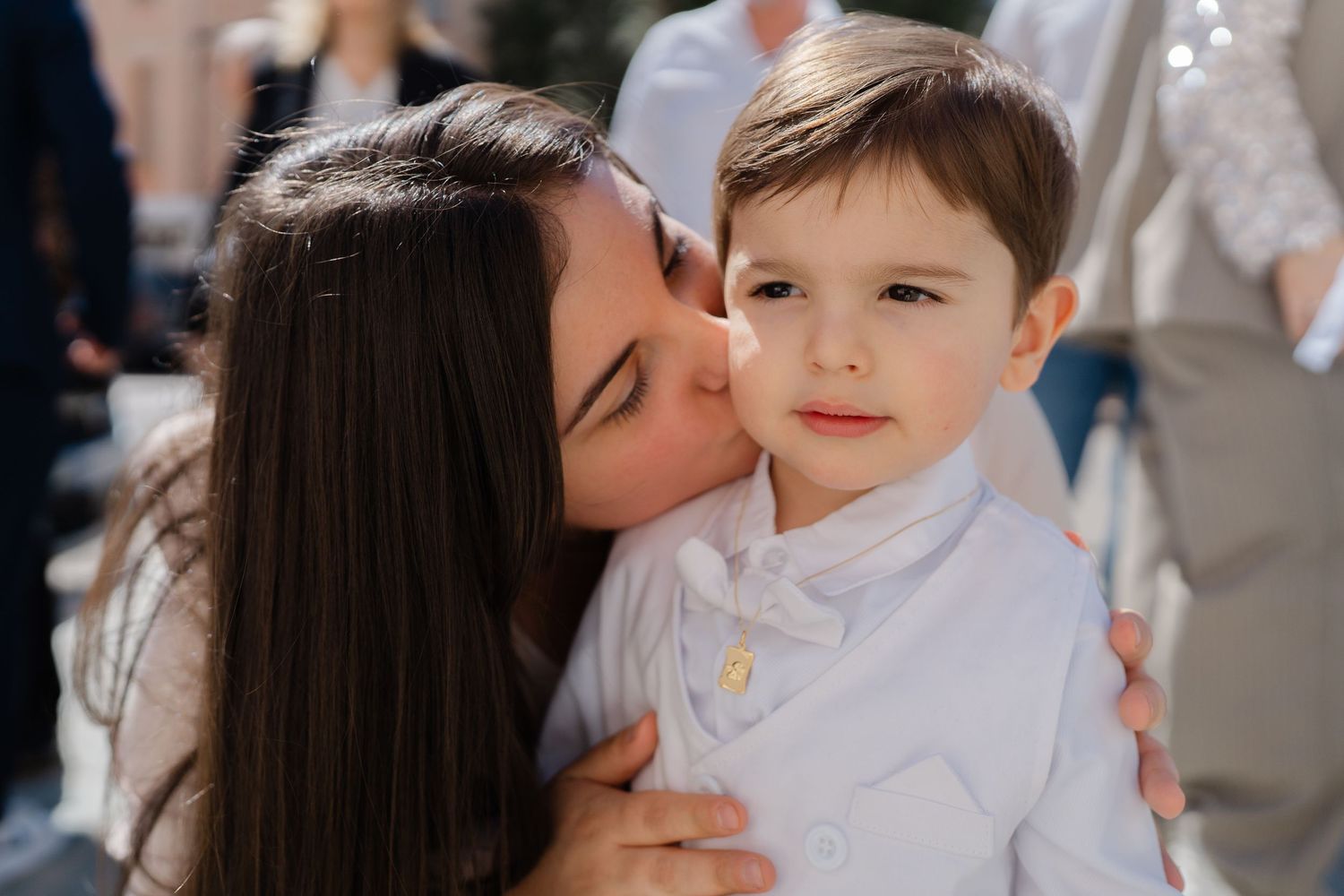 A tender moment captured outdoors on a sunny day.