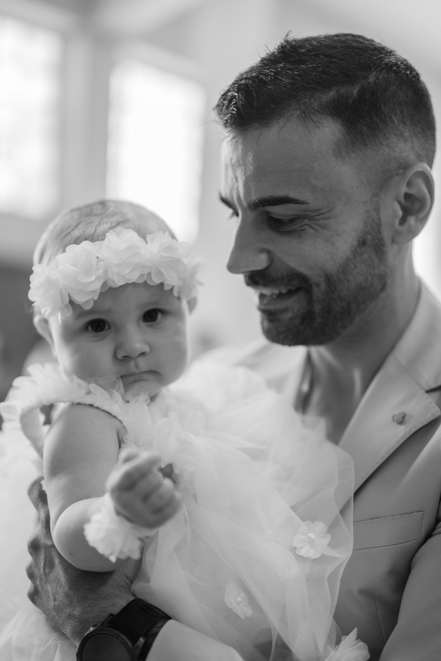 A series of four black and white photos showing intimate moments between a couple with white flowers.
