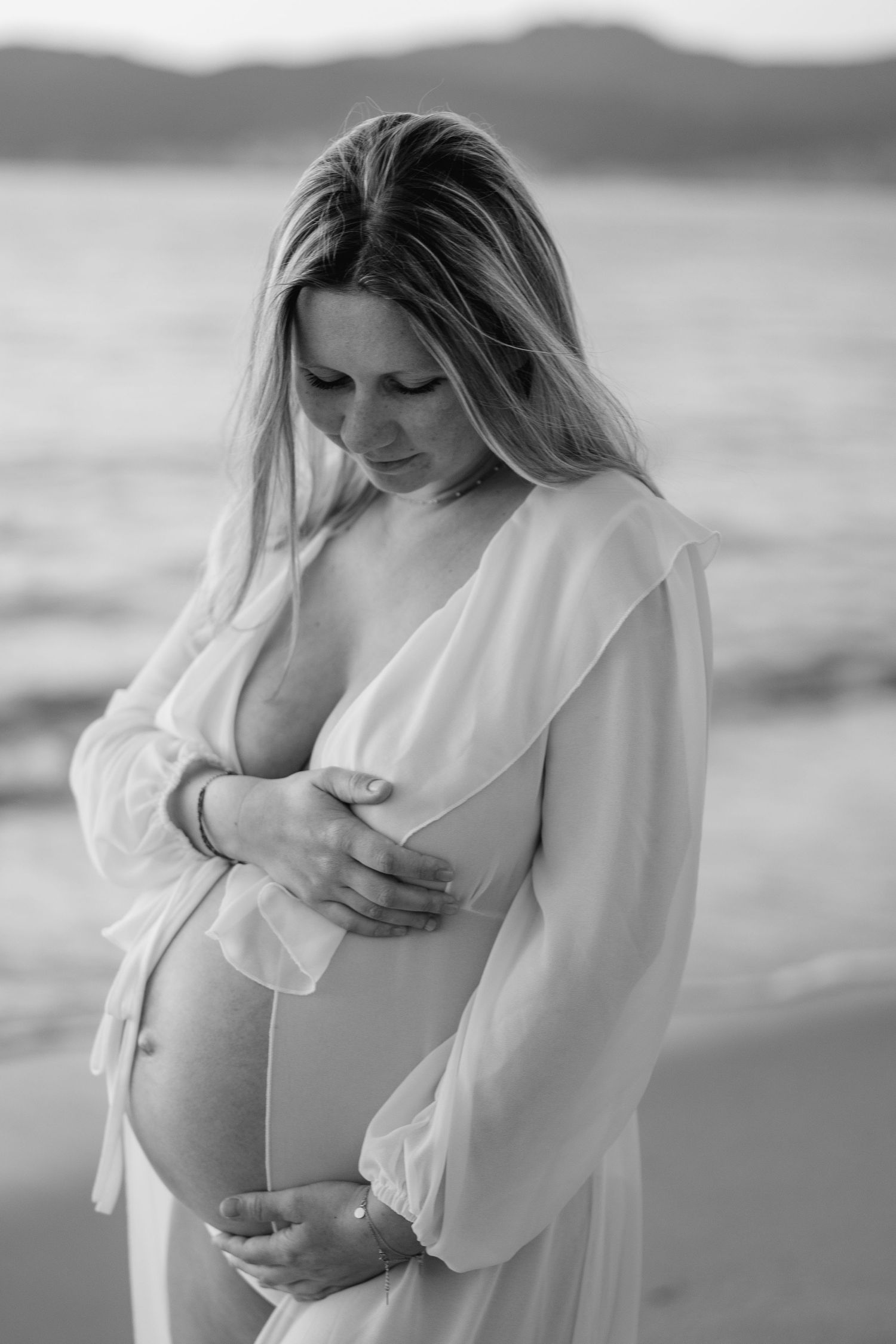Une photo  d'une future maman sereine au coucher du soleil.
