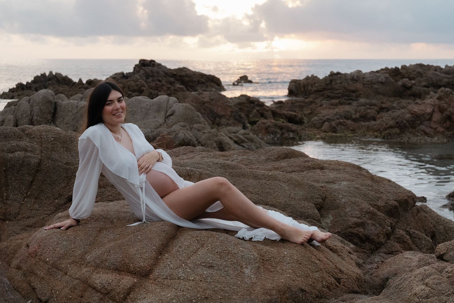 Une photo romantique d'une future maman au coucher du soleil.