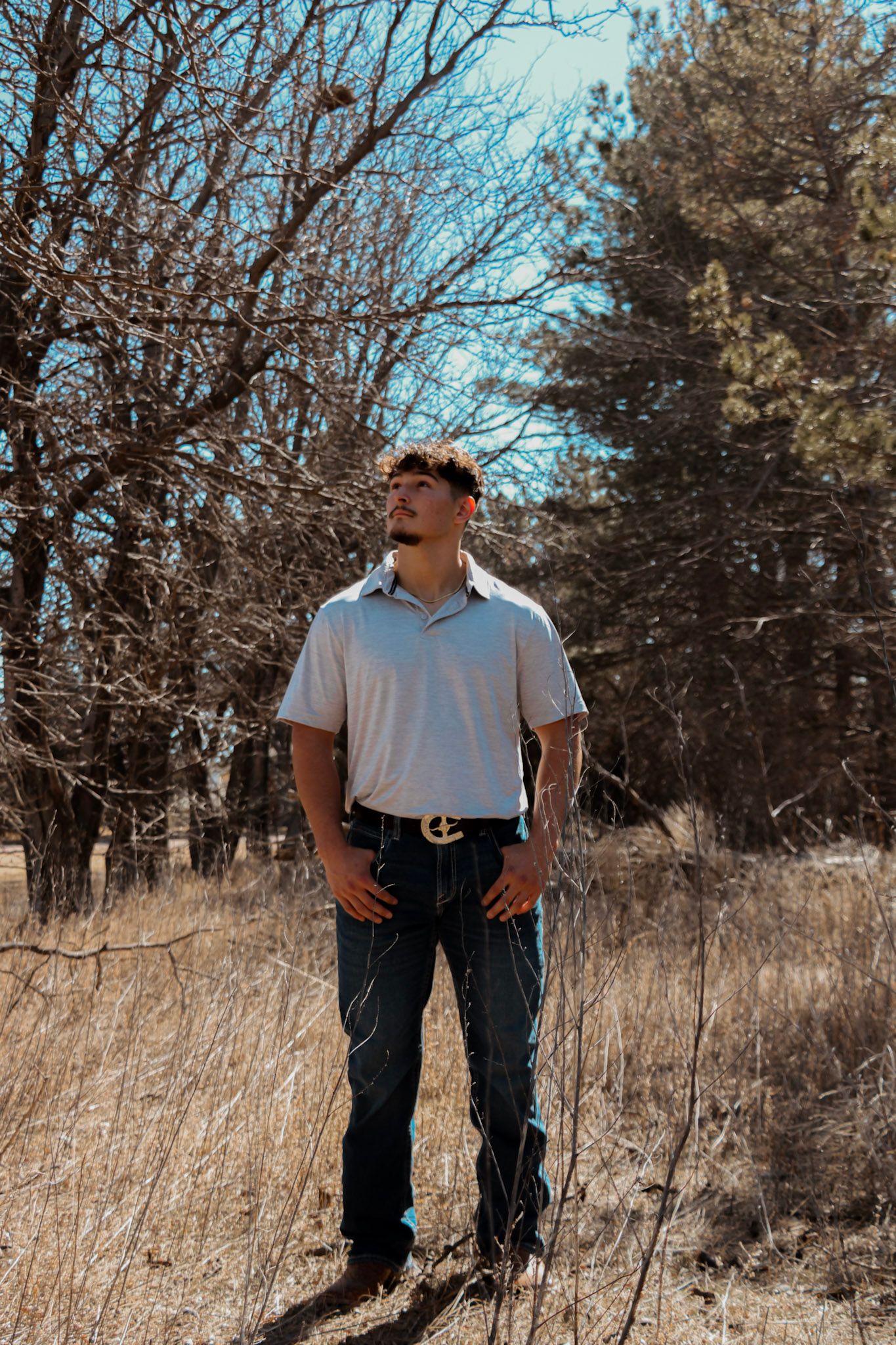 A series of similar outdoor shots showing a figure standing in tall dry grass with bare trees in the background.