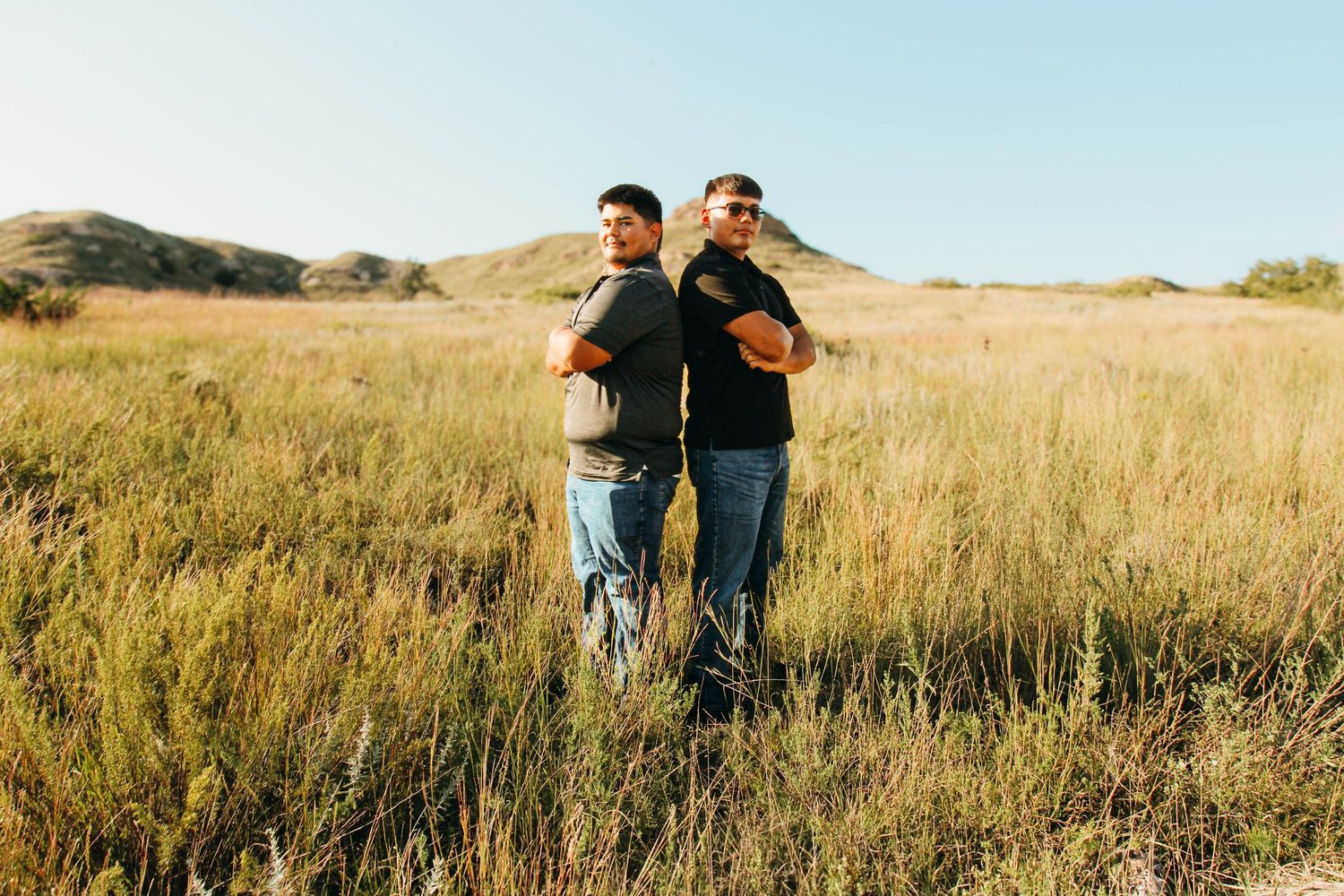 Couple walking together through a golden autumn field during sunset while holding hands.