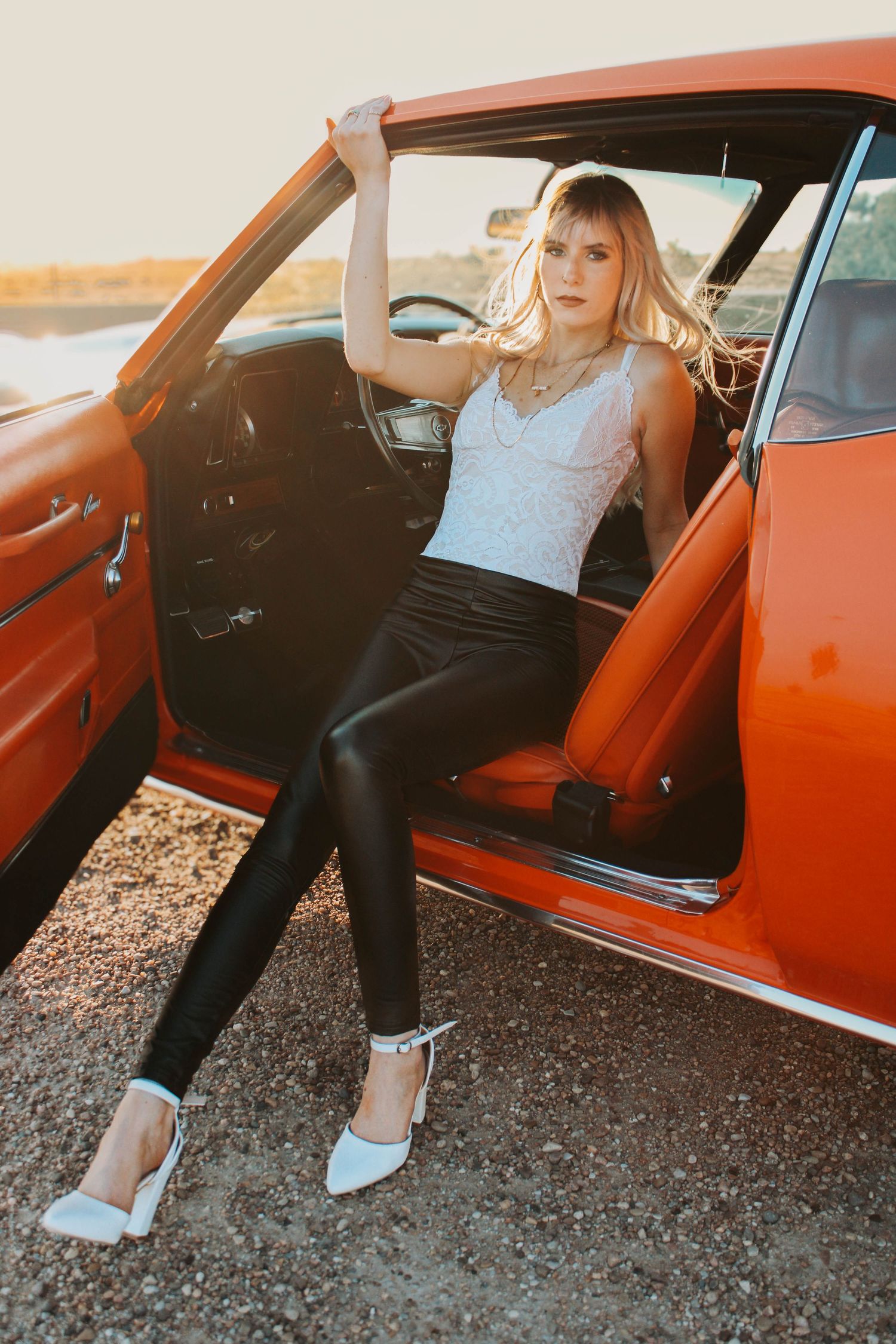 A sequence of photos showing someone getting into an orange vintage car parked on gravel ground.