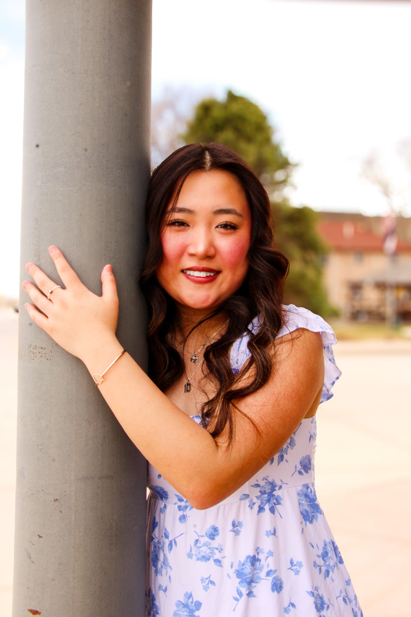 A sequence of cheerful poses captured between white columns outdoors on a sunny day.