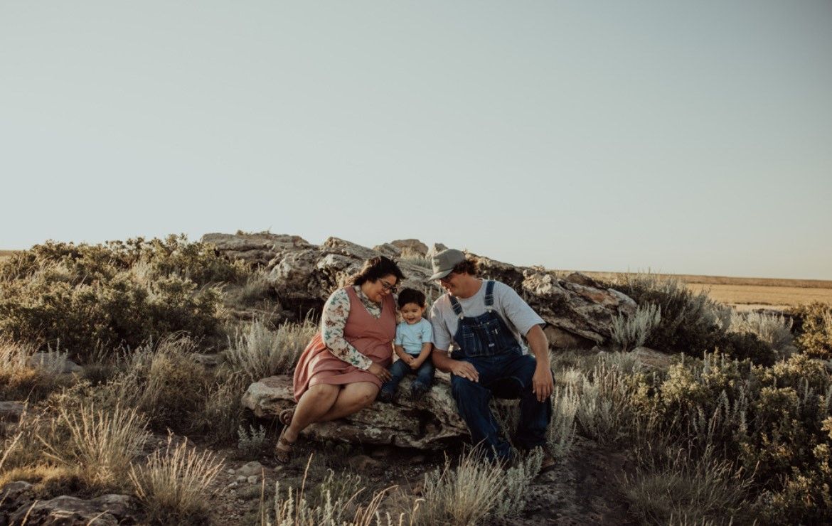 Family members gather on desert rocks during a sunset photoshoot.