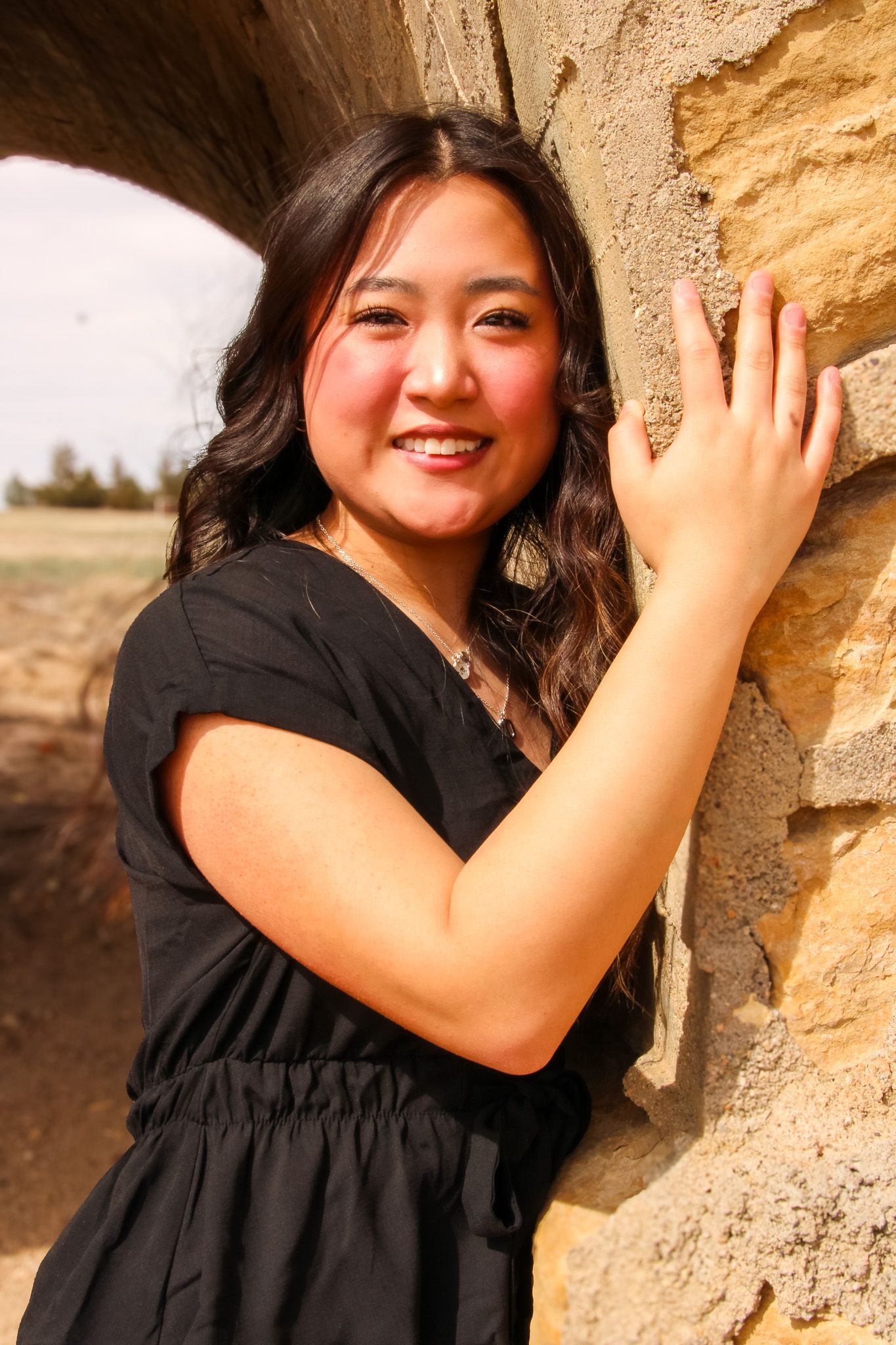 A series of portraits showing joyful expressions against a textured stone wall backdrop in warm lighting.