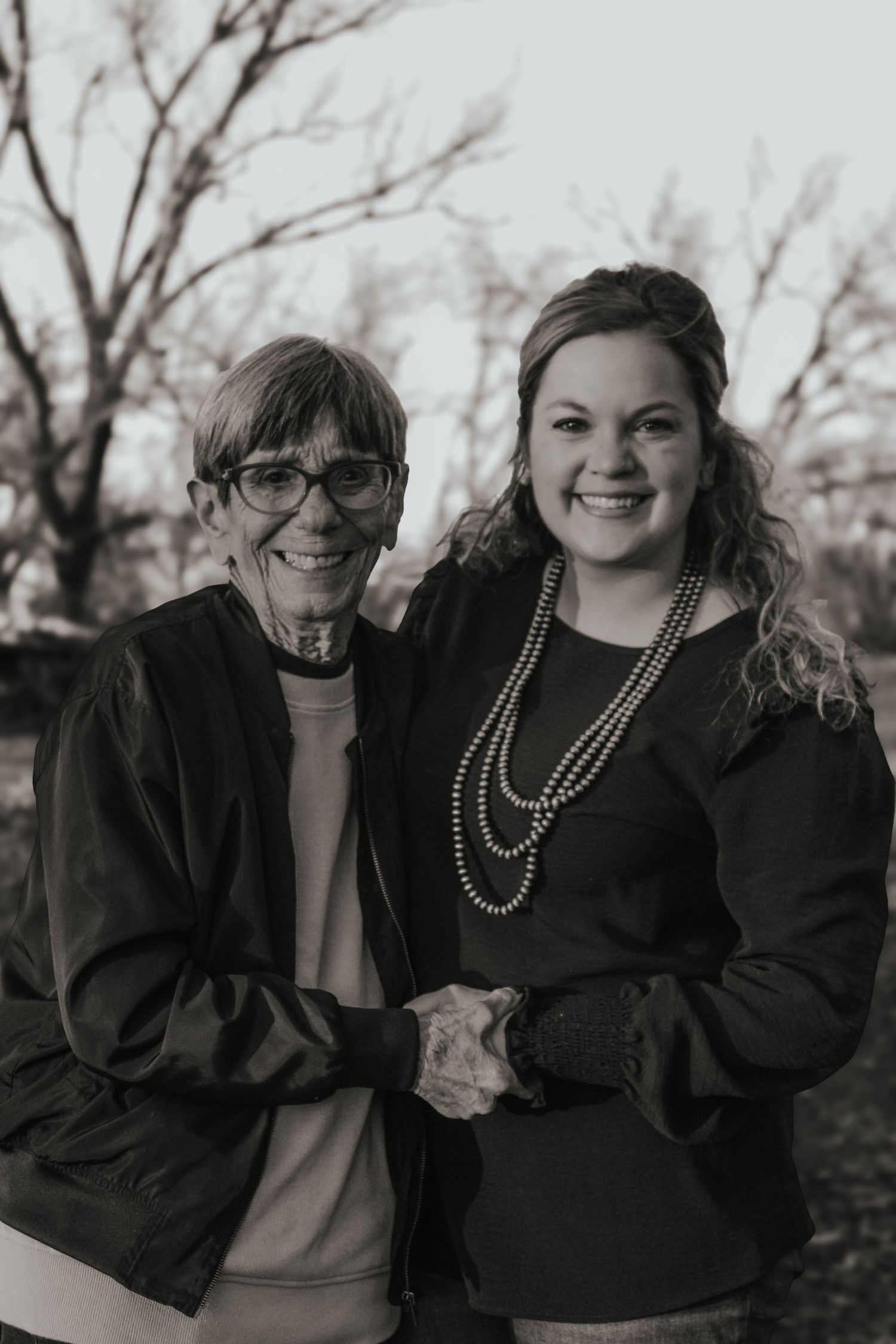 Two generations pose together in black and white against a natural backdrop.