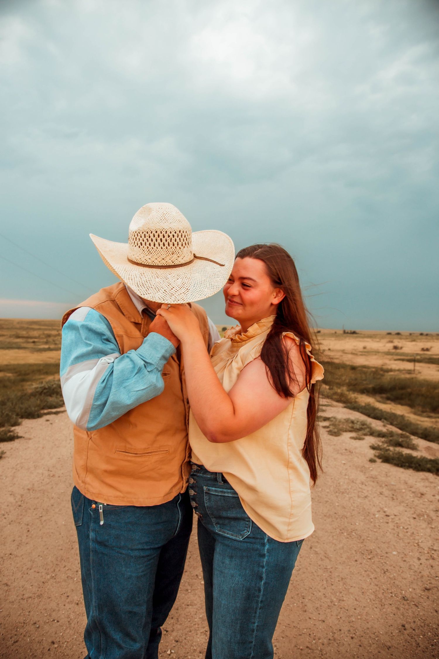 A romantic series of candid moments between a couple on a desert path, sharing laughter and embraces.