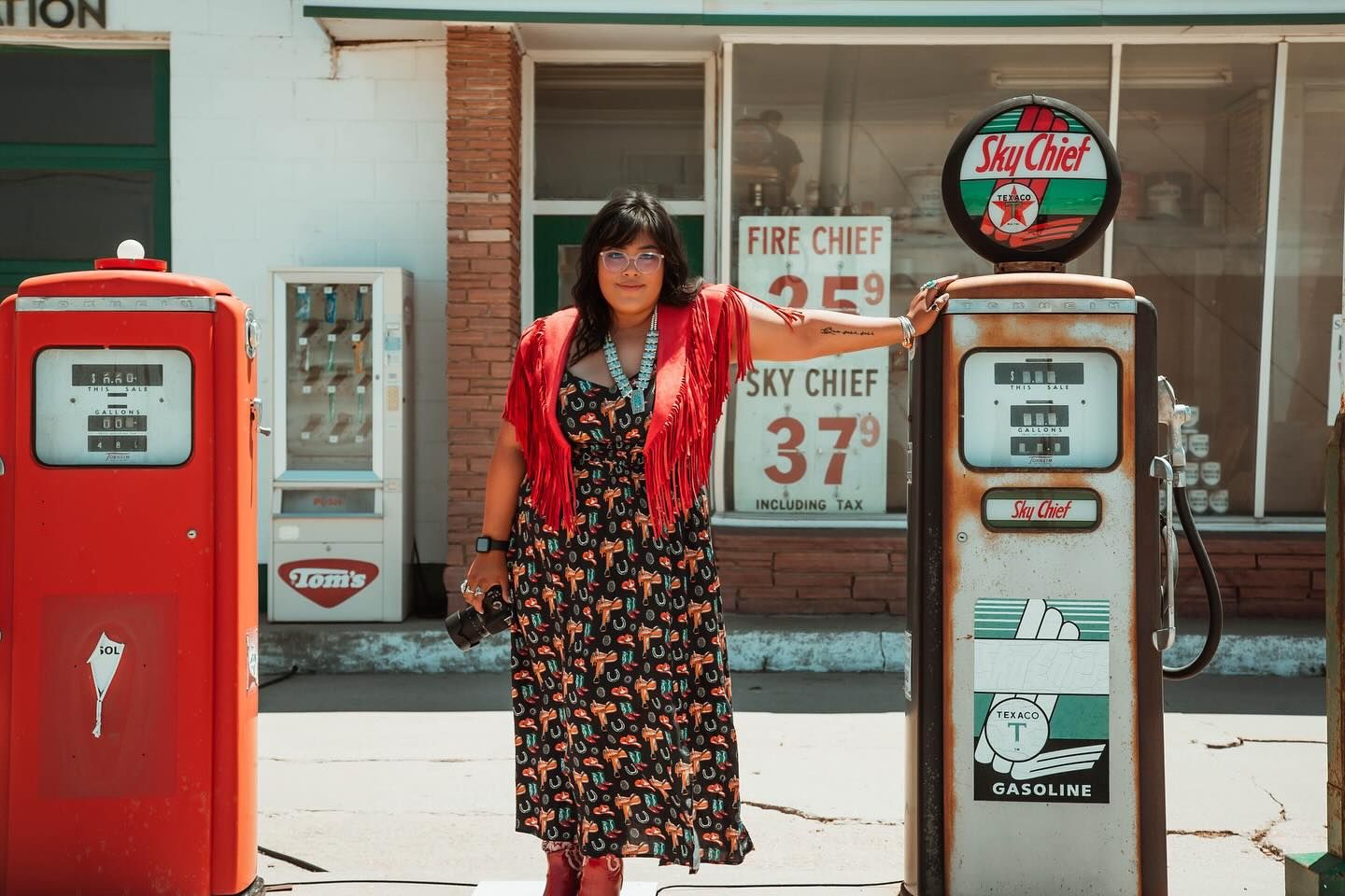 Vintage gas station with retro red pumps and signs displays nostalgic Americana atmosphere.