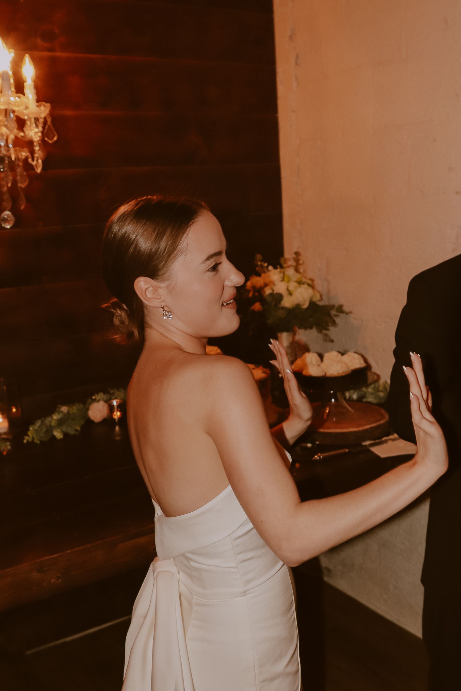 Bride in strapless dress dances and celebrates at wedding reception.