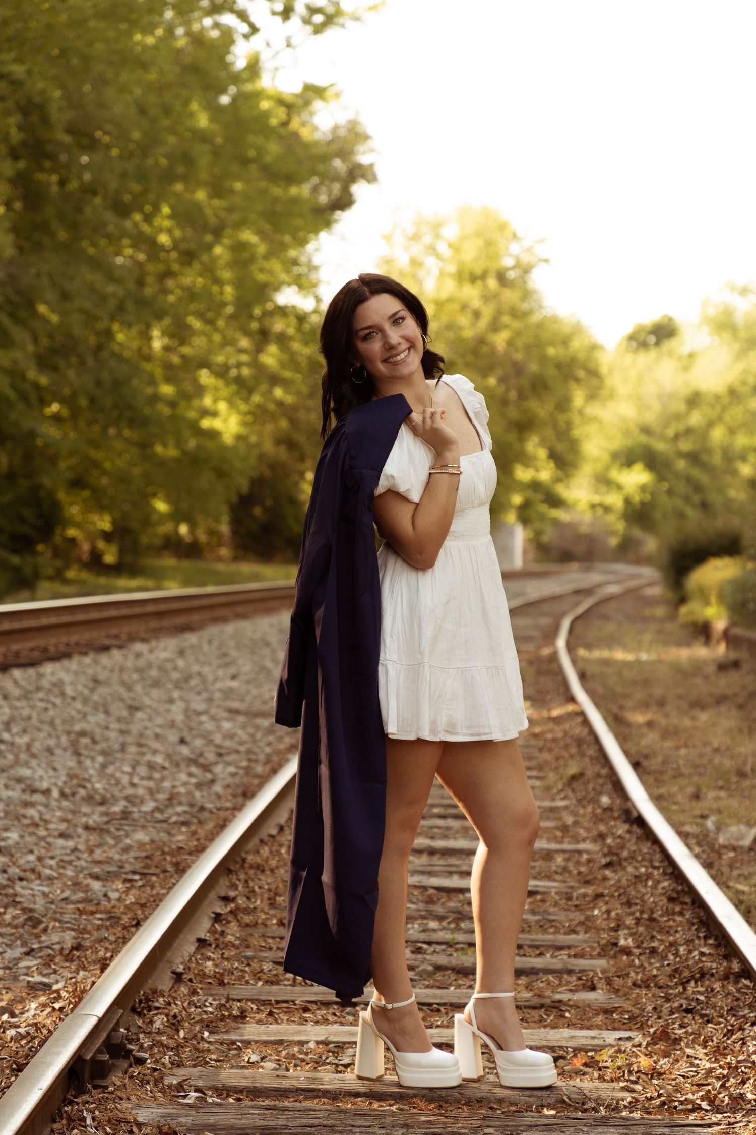 A series of artistic photos on railroad tracks at sunset with warm lighting and golden leaves on the ground.