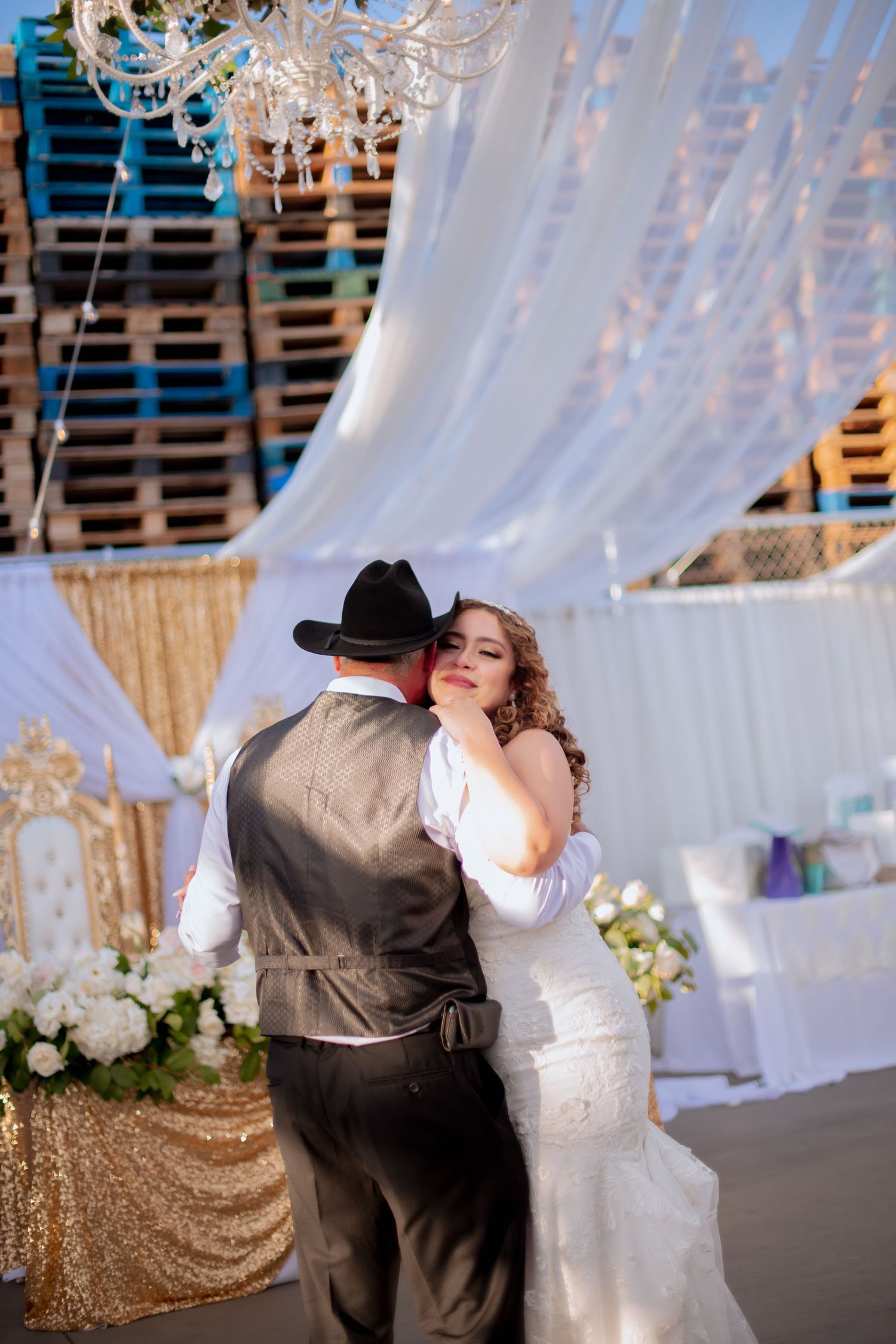Wedding Father and daughter shares a dance moment under decorative white draping and crystal chandeliers.