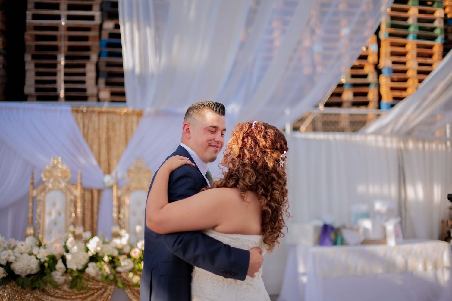 Wedding dance sequence captured under elegant white draping and decorative lighting.
