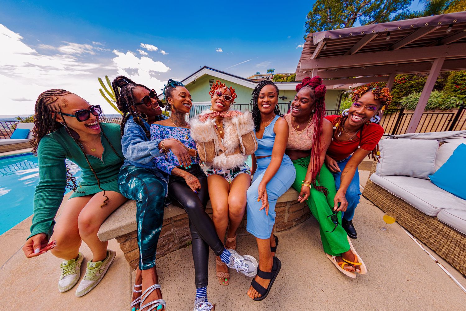 Group of friends on a wooden deck enjoy a sunny tropical getaway together near the beach.