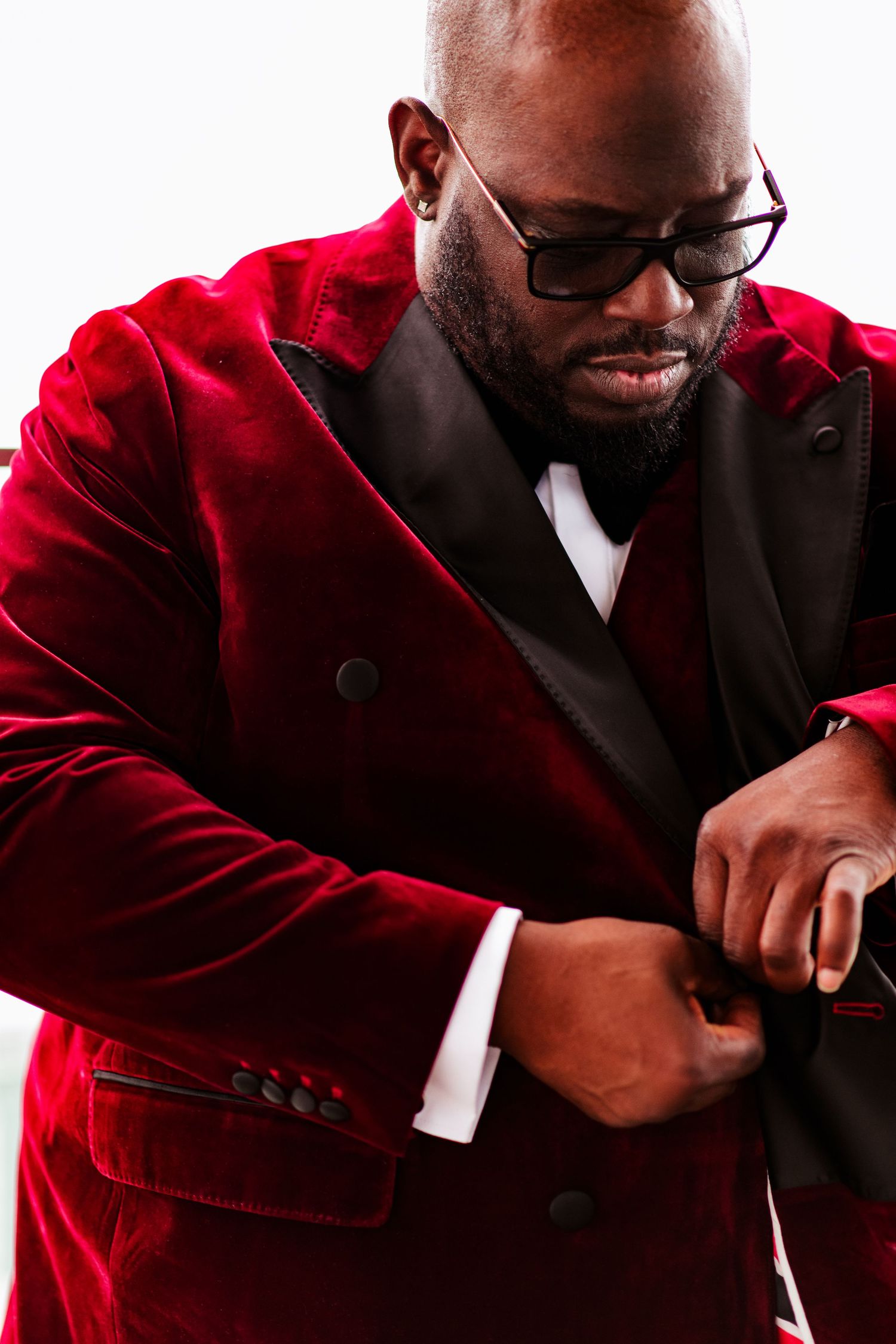 A series of candid shots showing someone in a burgundy velvet jacket and glasses laughing heartily.