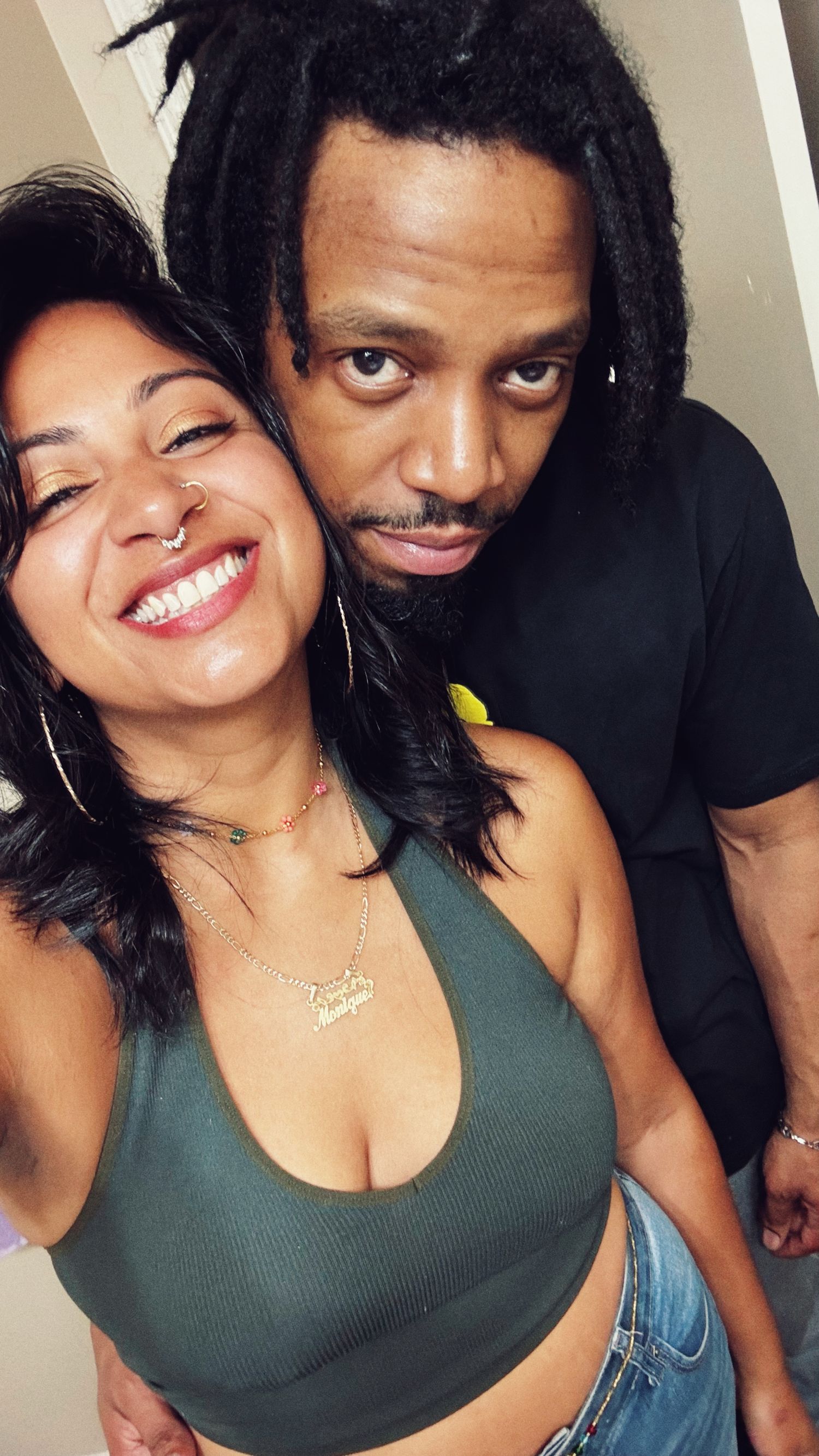 Casual indoor couple portrait showing genuine laughter and affection.