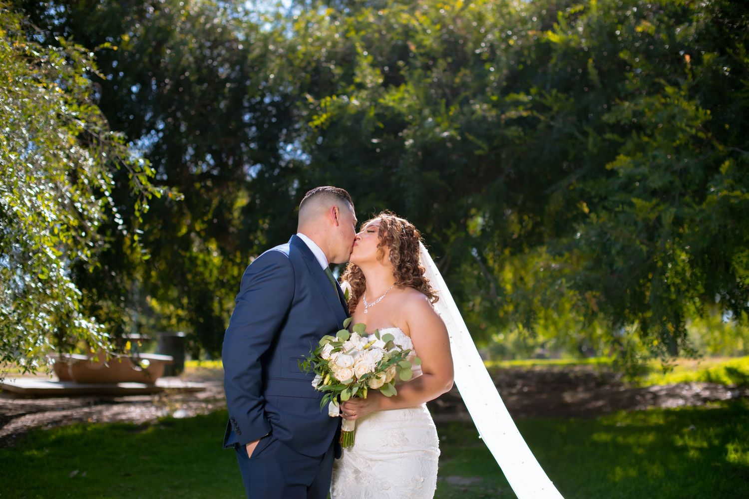 A romantic wedding photo sequence capturing a couple outdoors on a sunny day with flowing veil and natural backdrop.