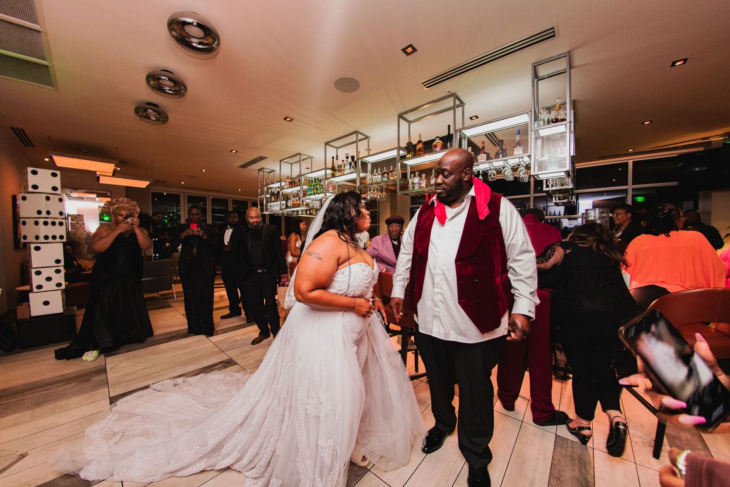 Elegant wedding celebration scene in a modern indoor venue with decorative lighting.