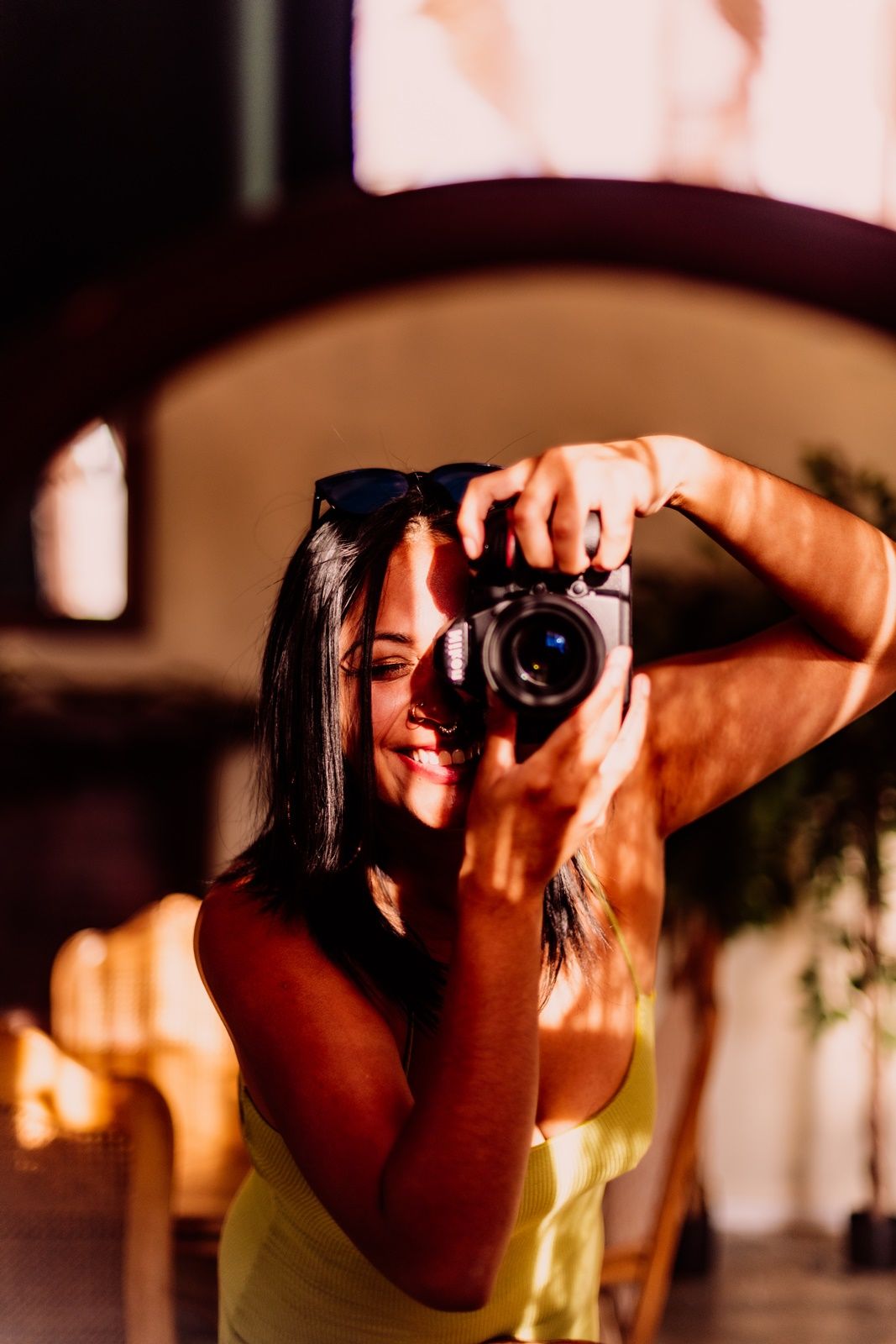 Artistic portrait with dramatic side lighting and sunglasses in warm tones.