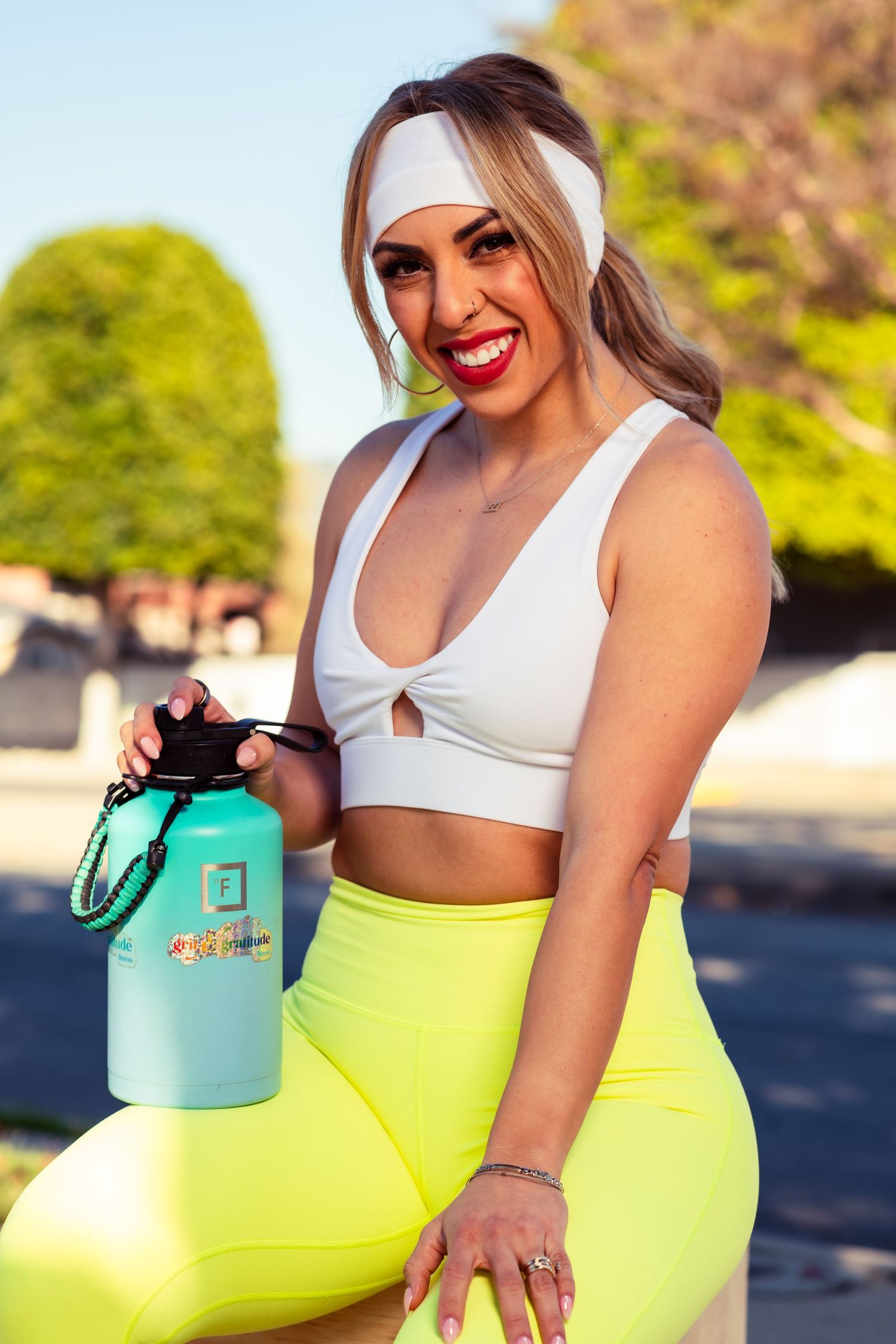 Athletic wear photo featuring bright yellow leggings and white sports top in outdoor setting.