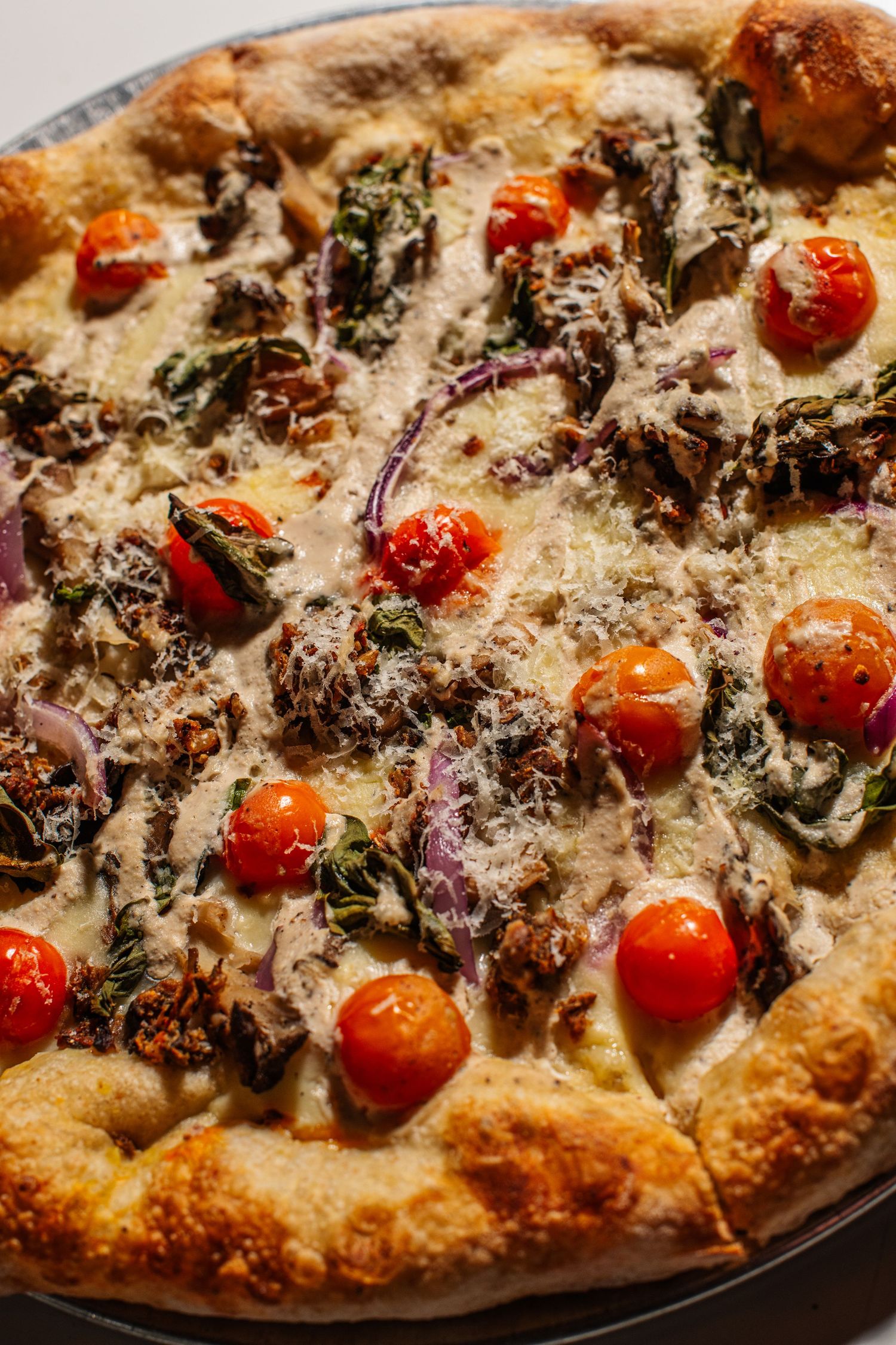 Artisanal pizza topped with roasted cherry tomatoes, caramelized onions, and melted cheese on a crispy crust.