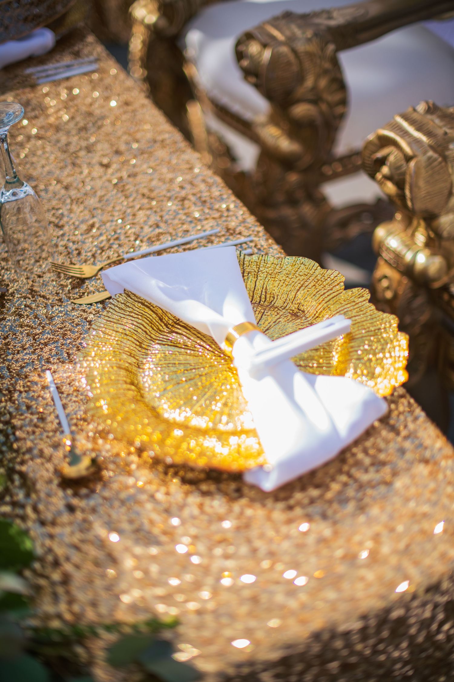 Golden butterfly detail on white fabric against sparkly textured surface.