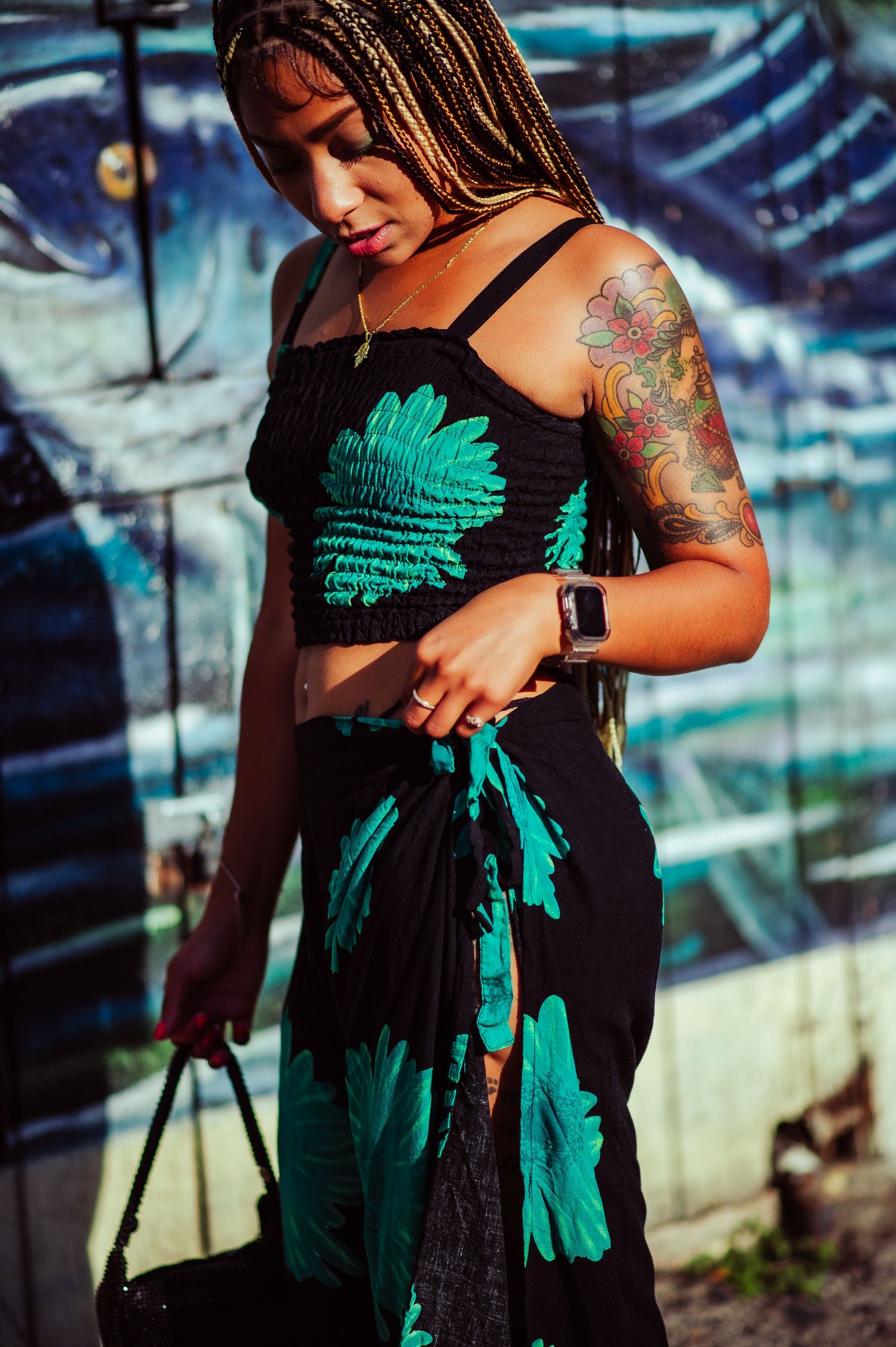 Fashion photo of a black and turquoise tropical print outfit against an artistic blue backdrop.