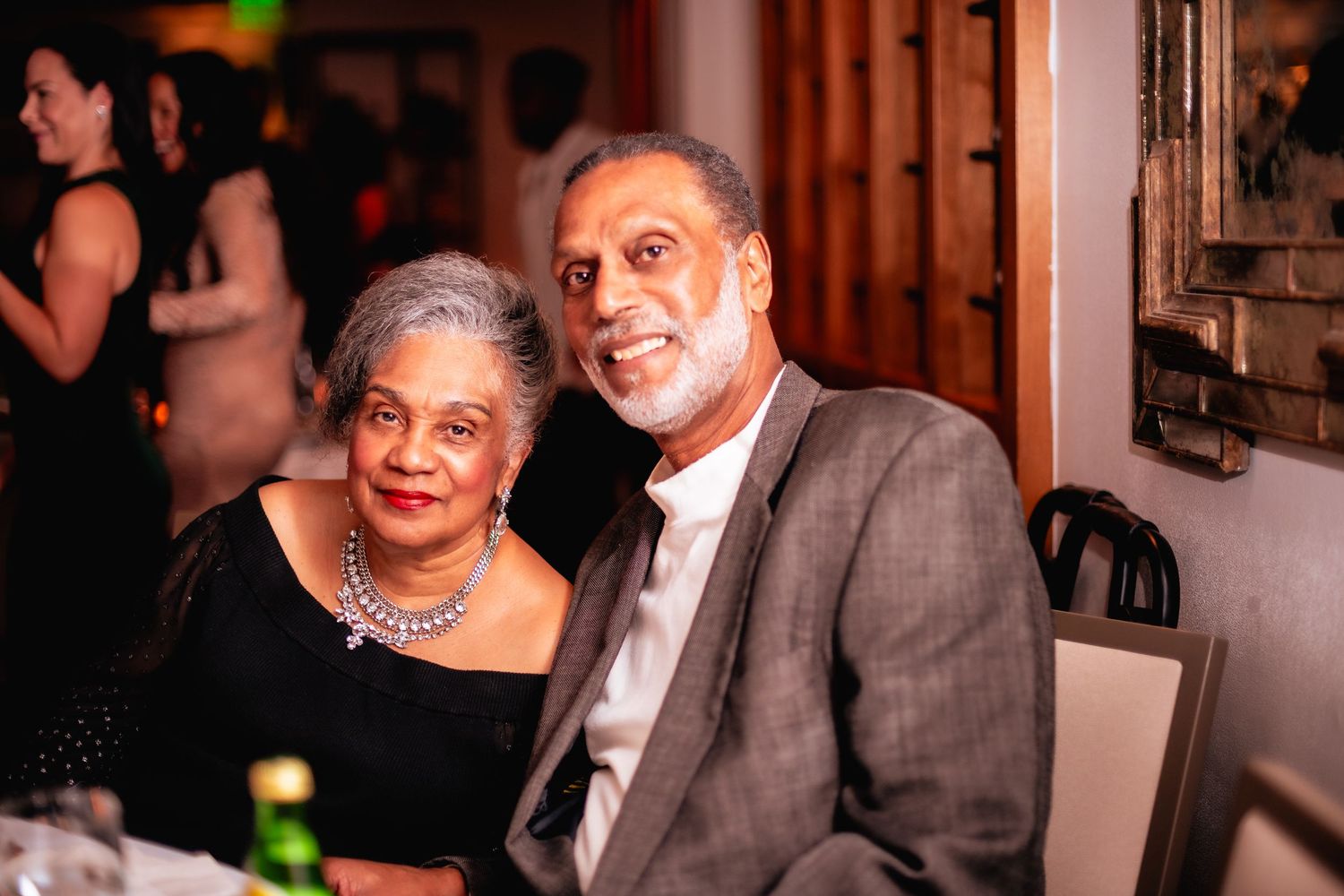 Friends gathered for a celebration in a warmly lit room with elegant decor.