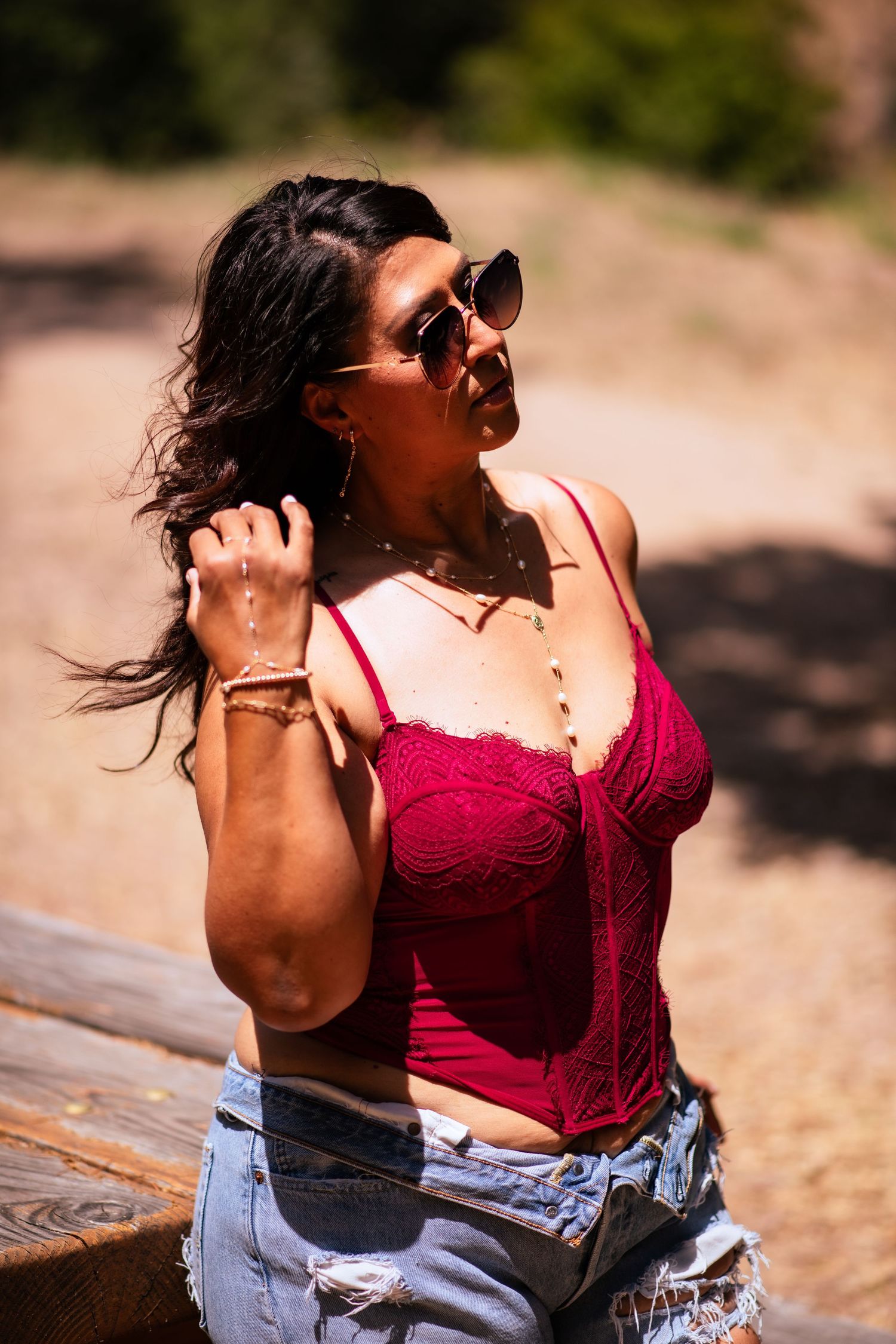 A series of shots showing a person in a red top and denim shorts outdoors on a sunny day with wind-blown hair.