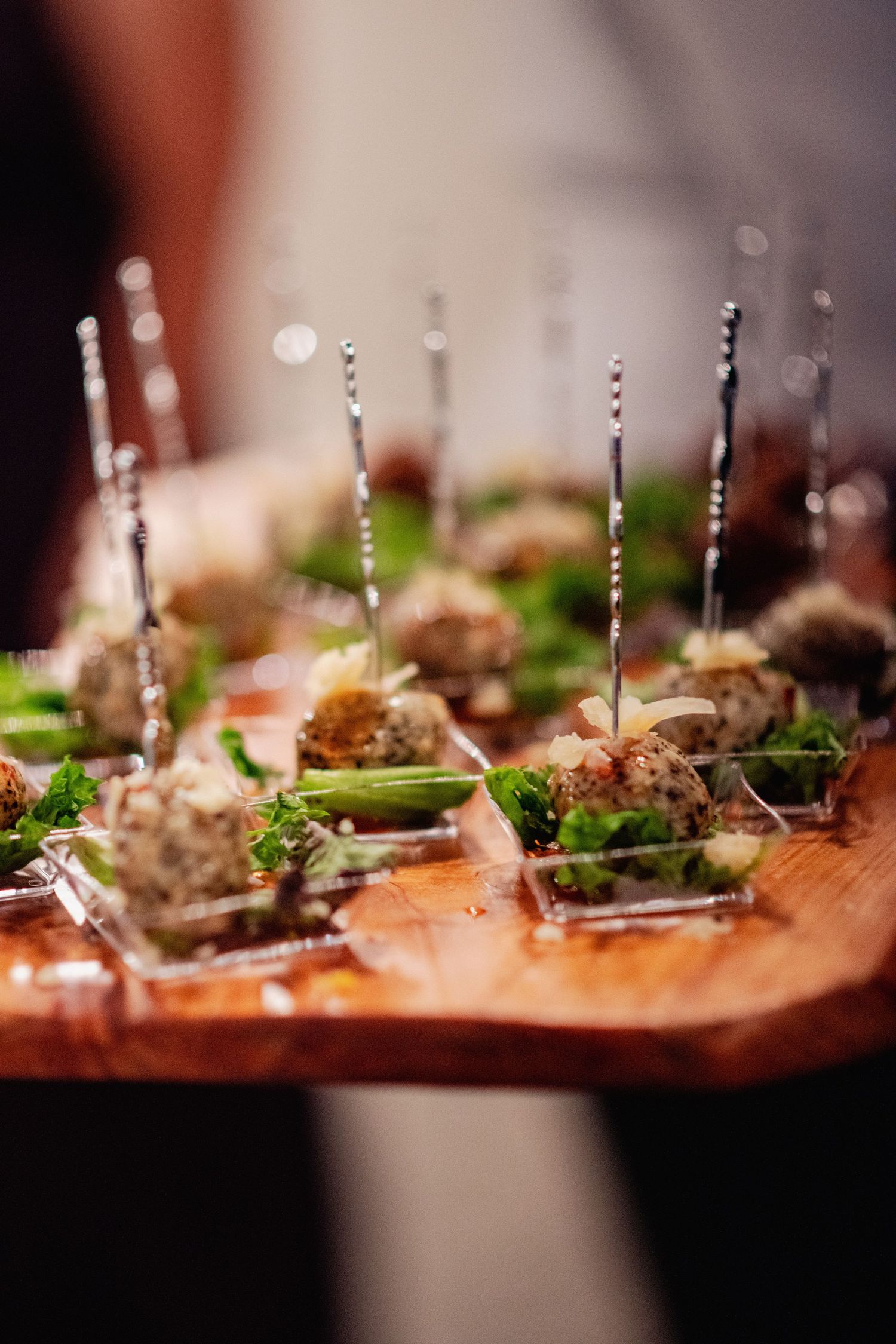 Close-up shallow depth of field view of gourmet appetizers with garnish on small plates arranged in a line.