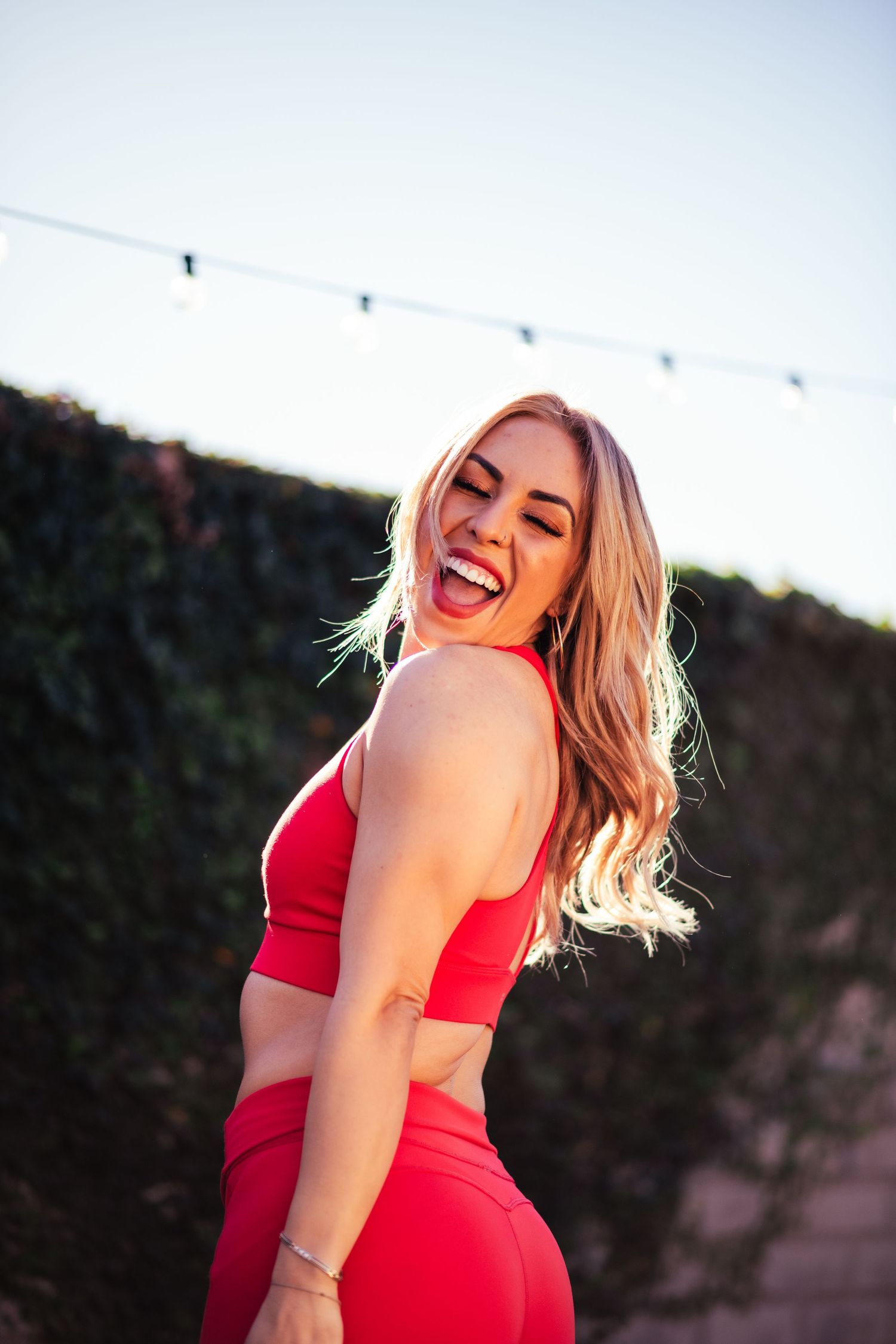 Joyful outdoor portrait session featuring bright red activewear ensemble.