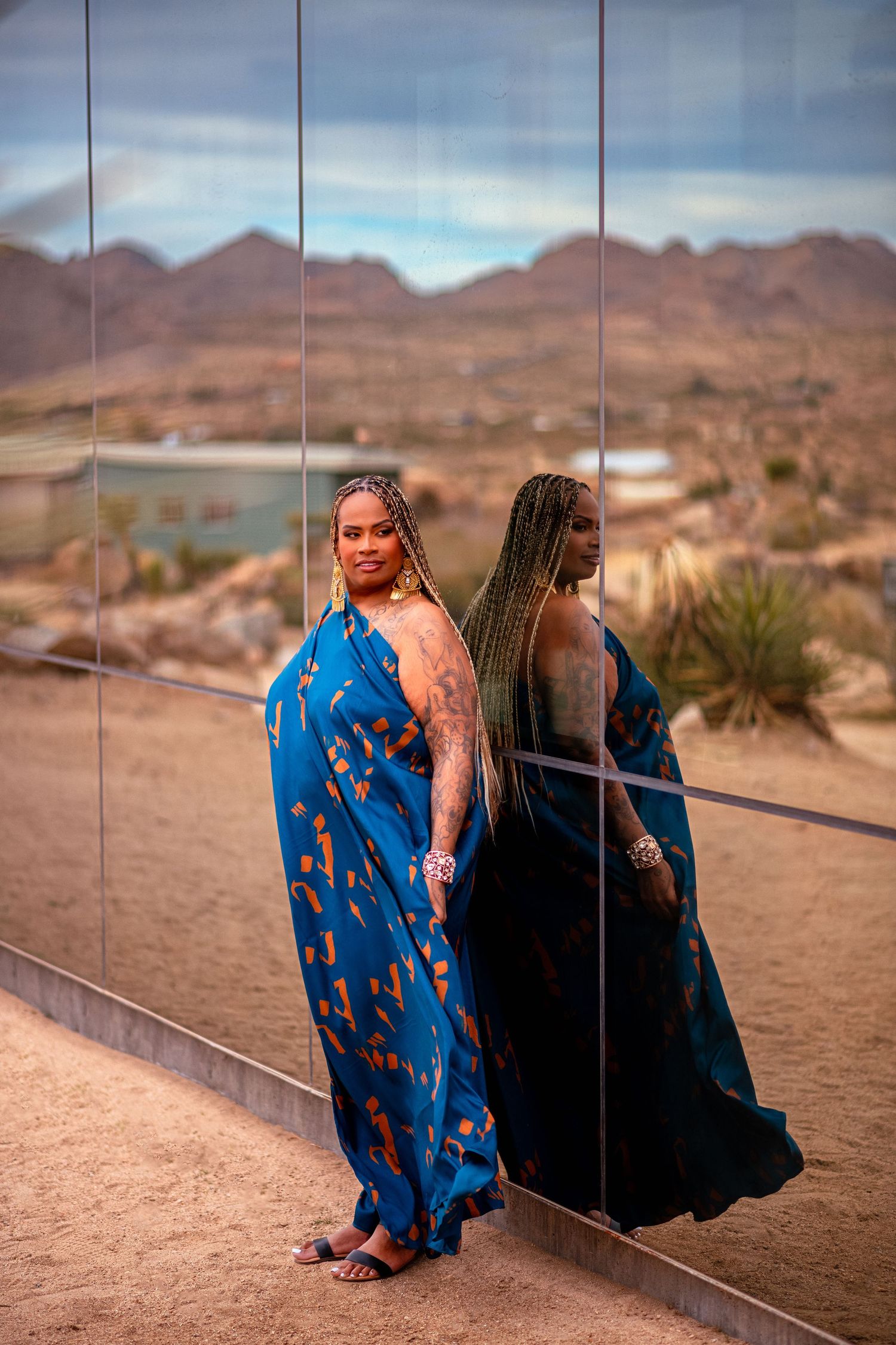 Creative desert photoshoot using mirror reflections and blue flowing dress.