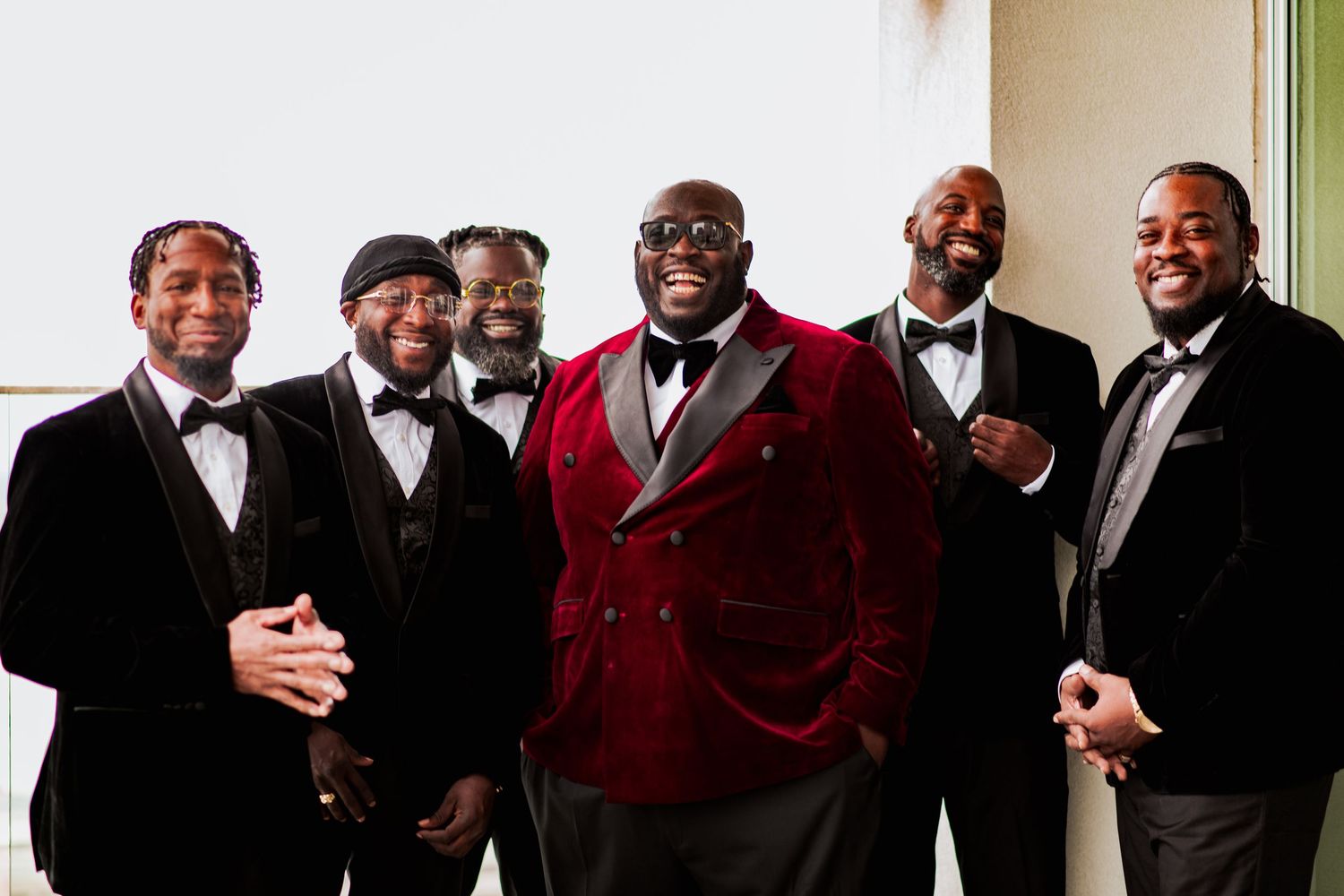 A group of formally dressed men in suits and formal attire pose together for a group photo.