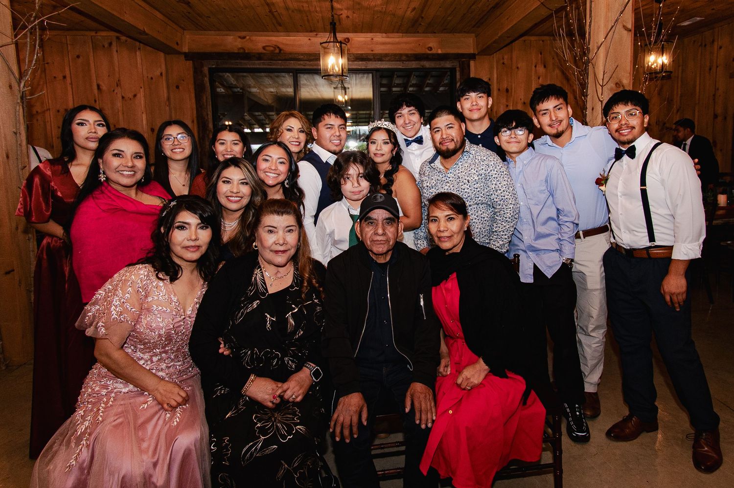 A large group of people gathered together at a formal event in a warmly lit indoor venue.