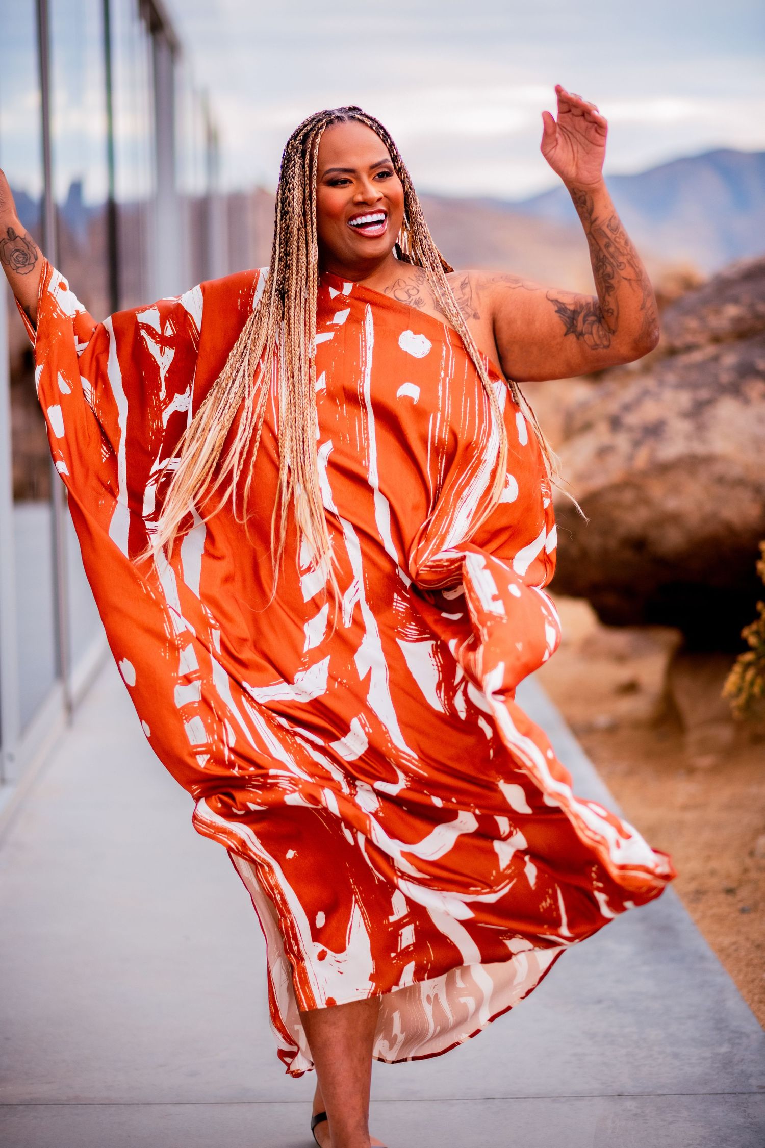 A person in a flowing orange dress twirls joyfully against a desert mountain backdrop in a series of dynamic photos.