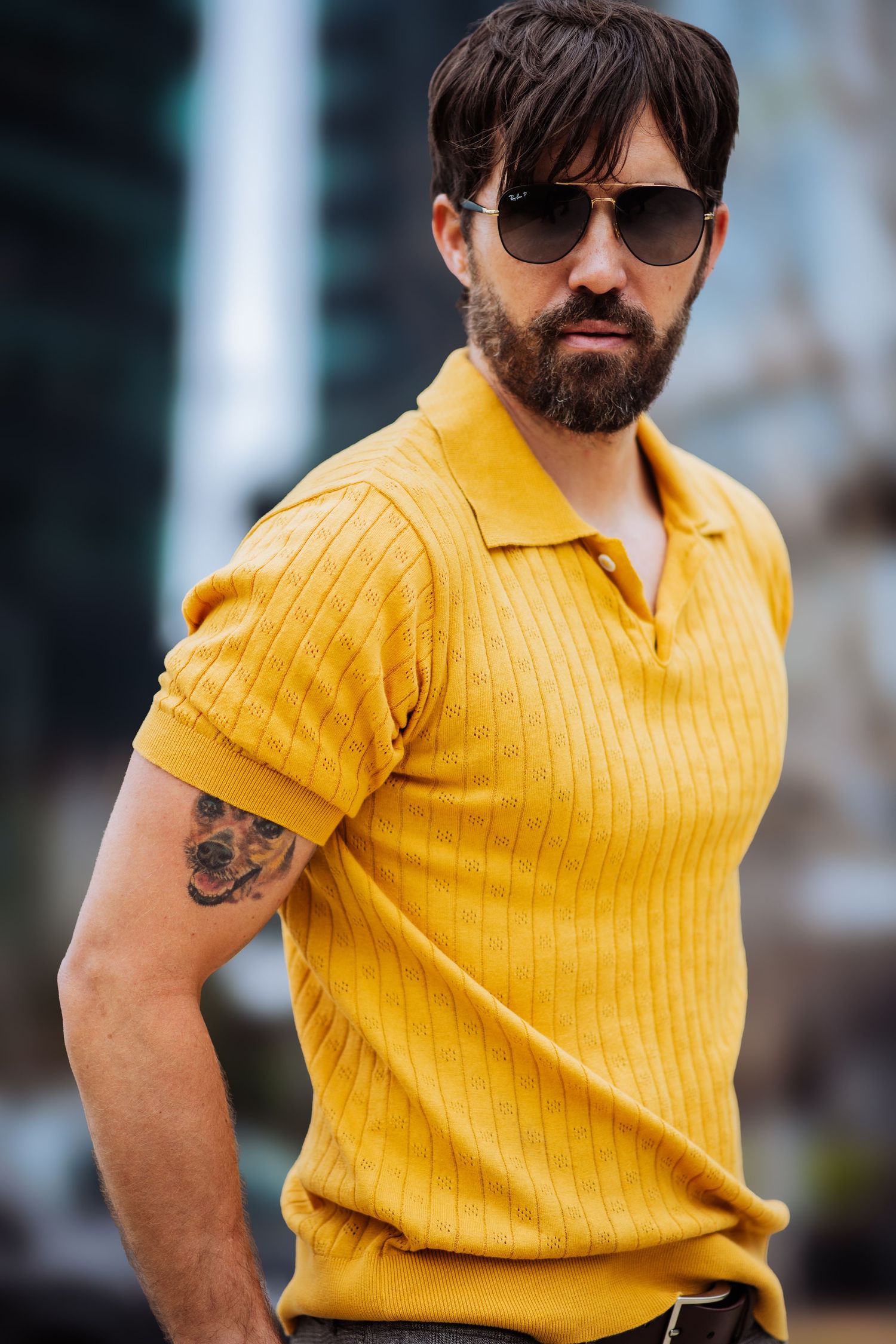 Side profile shot of person in yellow ribbed polo shirt wearing aviator sunglasses.