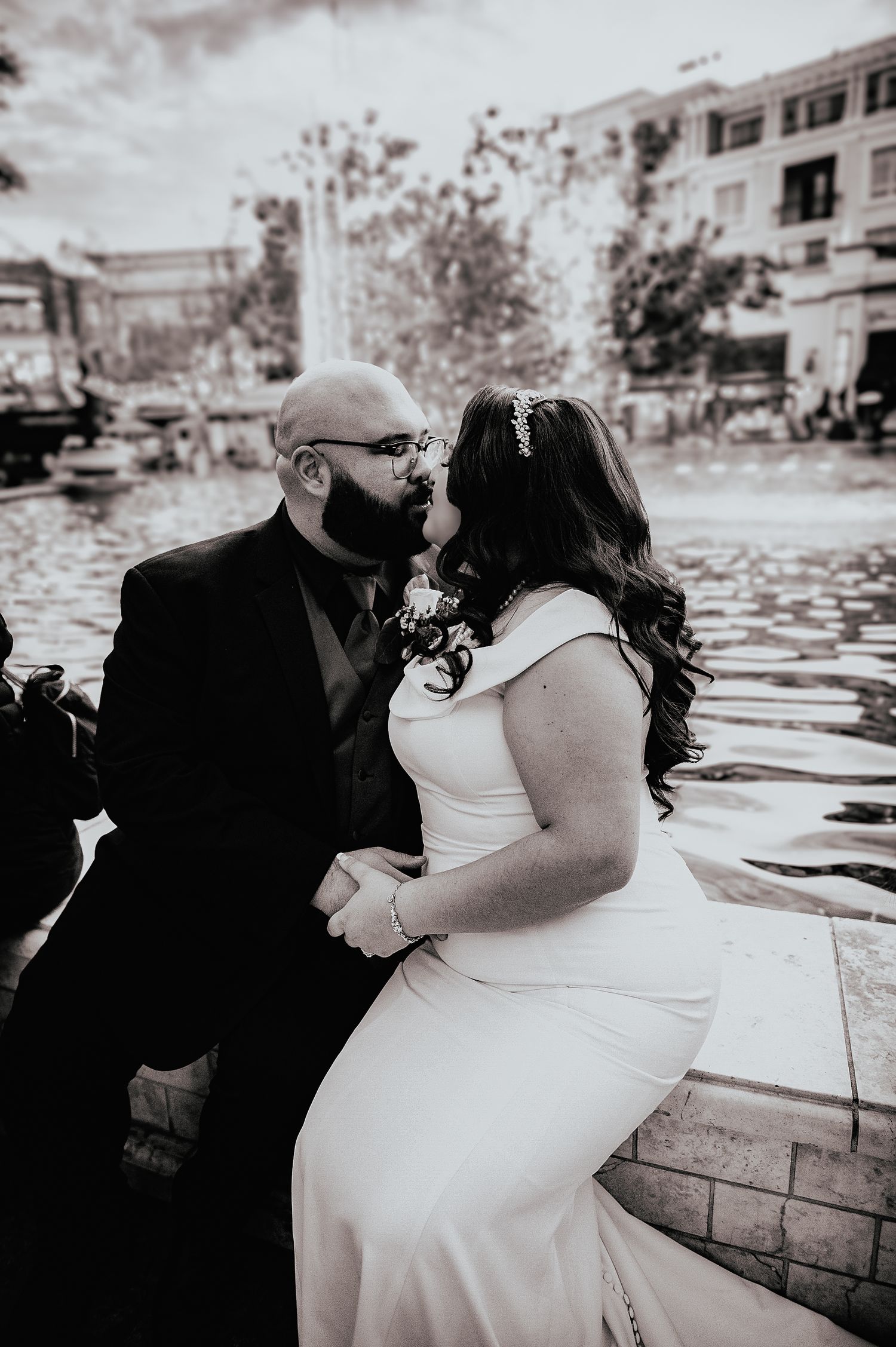 A romantic black and white photo series showing a couple sharing tender moments by a waterfront wall.