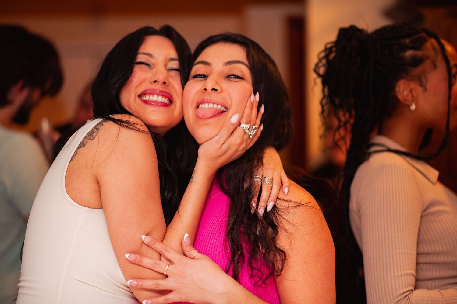 Friends sharing embraces and laughter during a celebratory gathering.