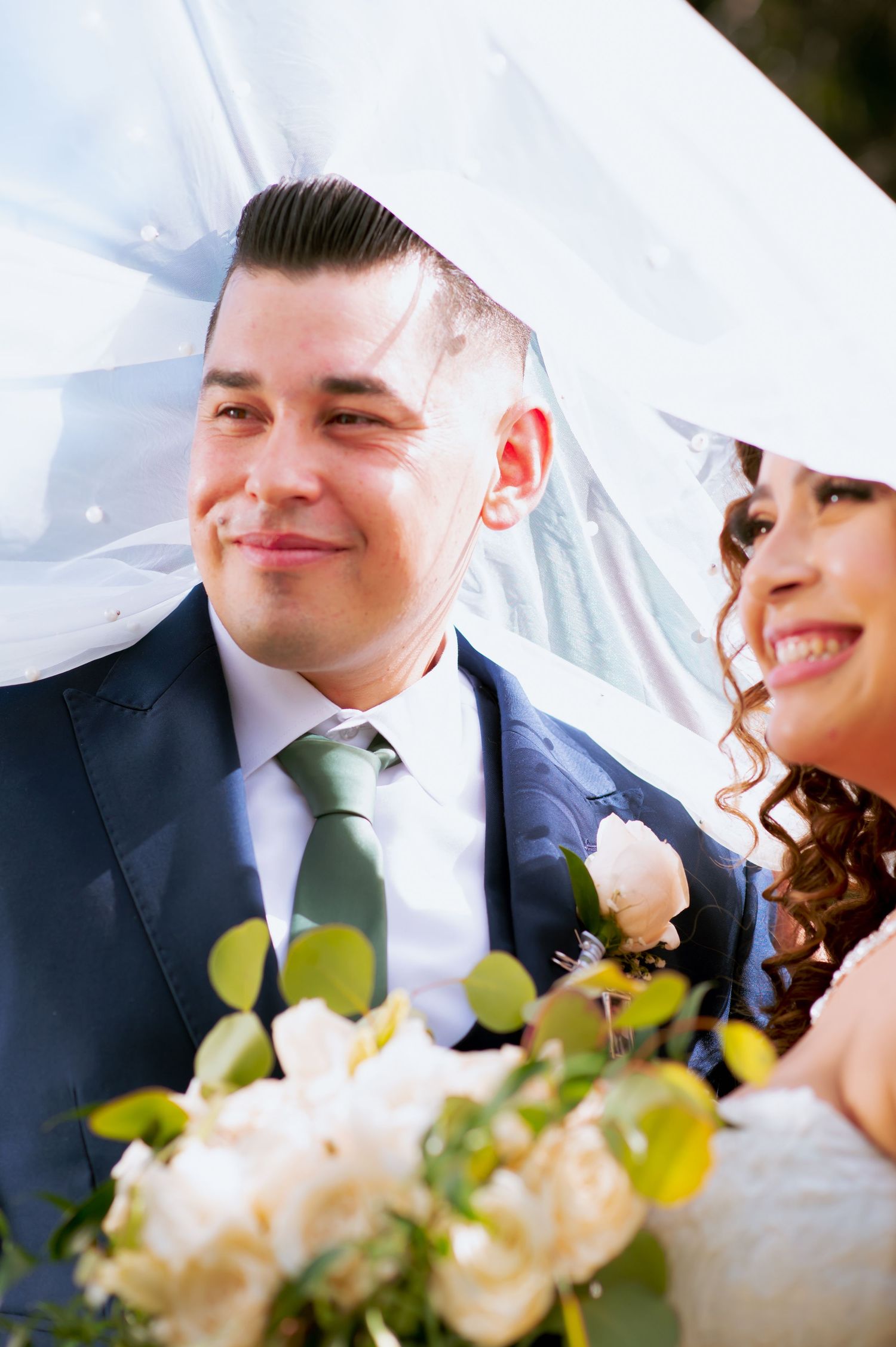 Intimate wedding moments captured with delicate flowers and flowing veil details.