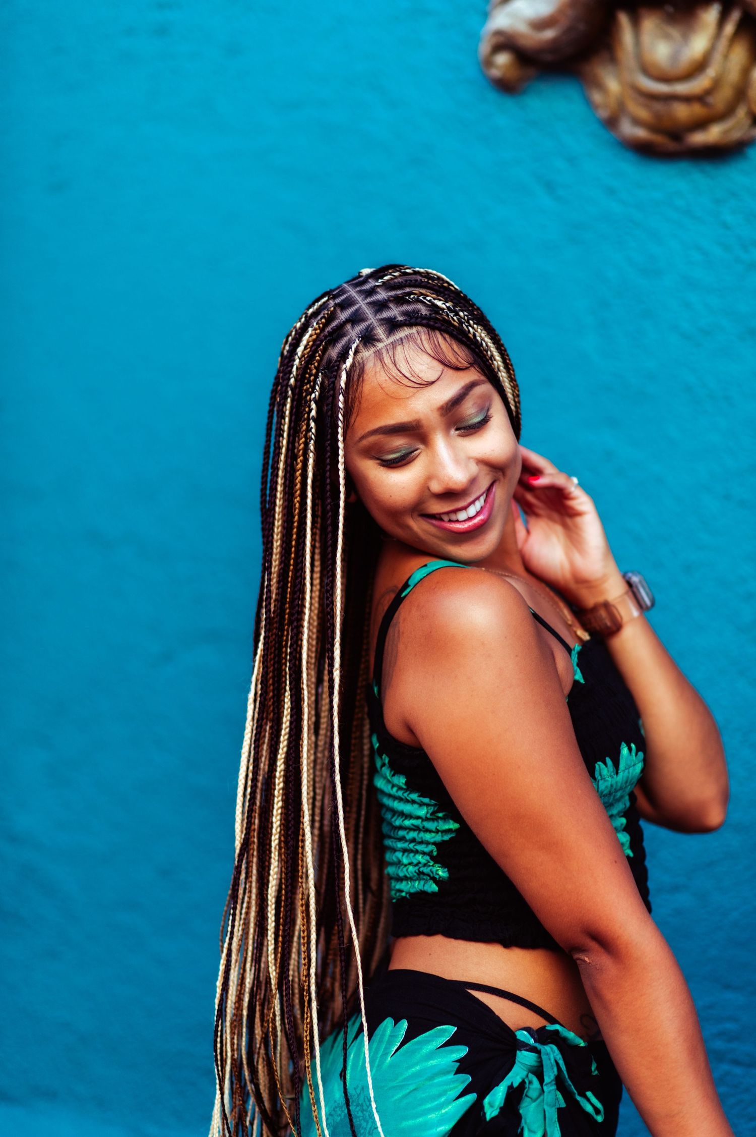 Cheerful summer fashion portraits against a bright blue wall showcasing a floral outfit.